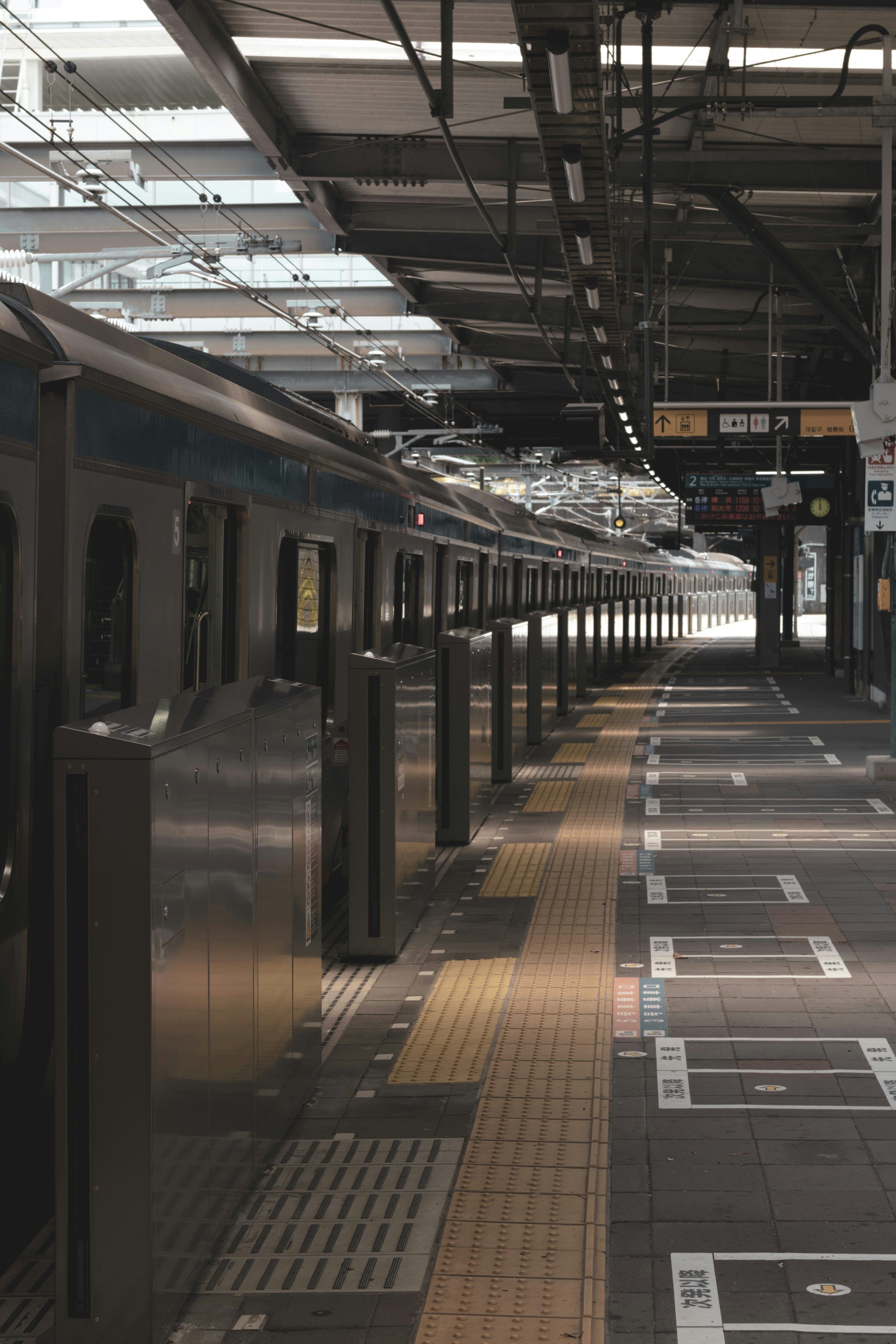 Plataforma de tren vacía con vagones alineados