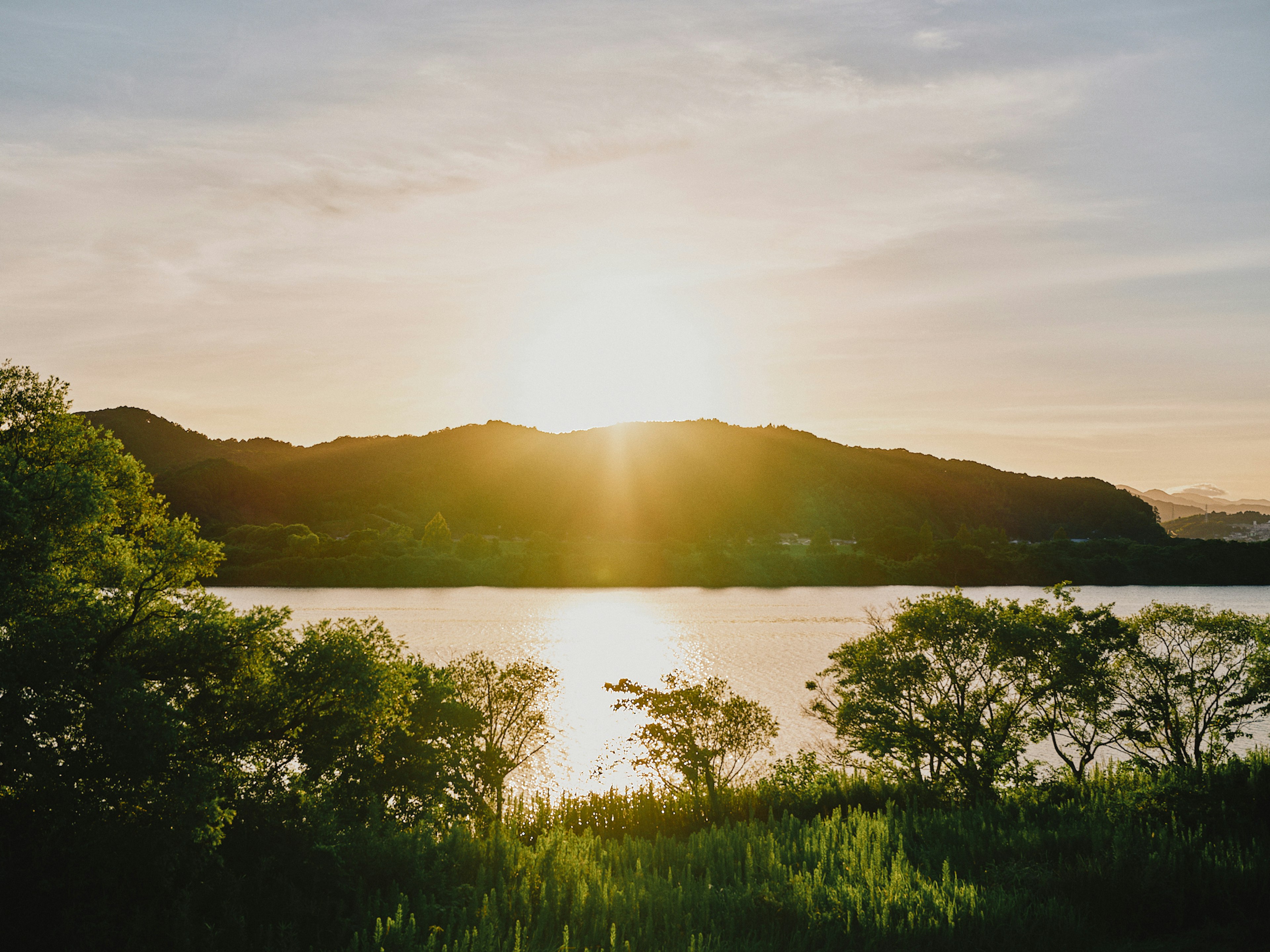 Serene lake landscape with sunset behind mountains