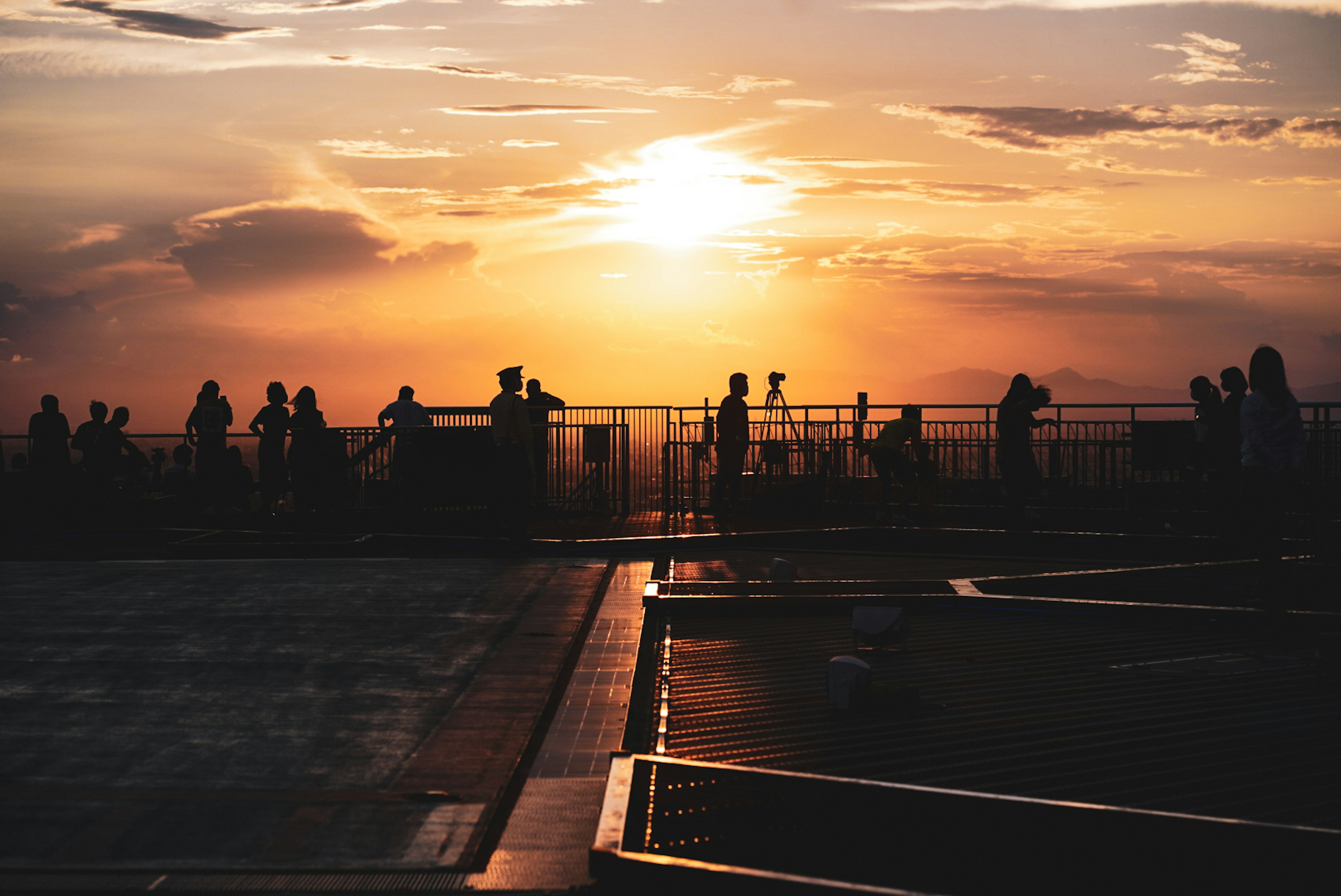 Rooftop view with silhouettes against a sunset