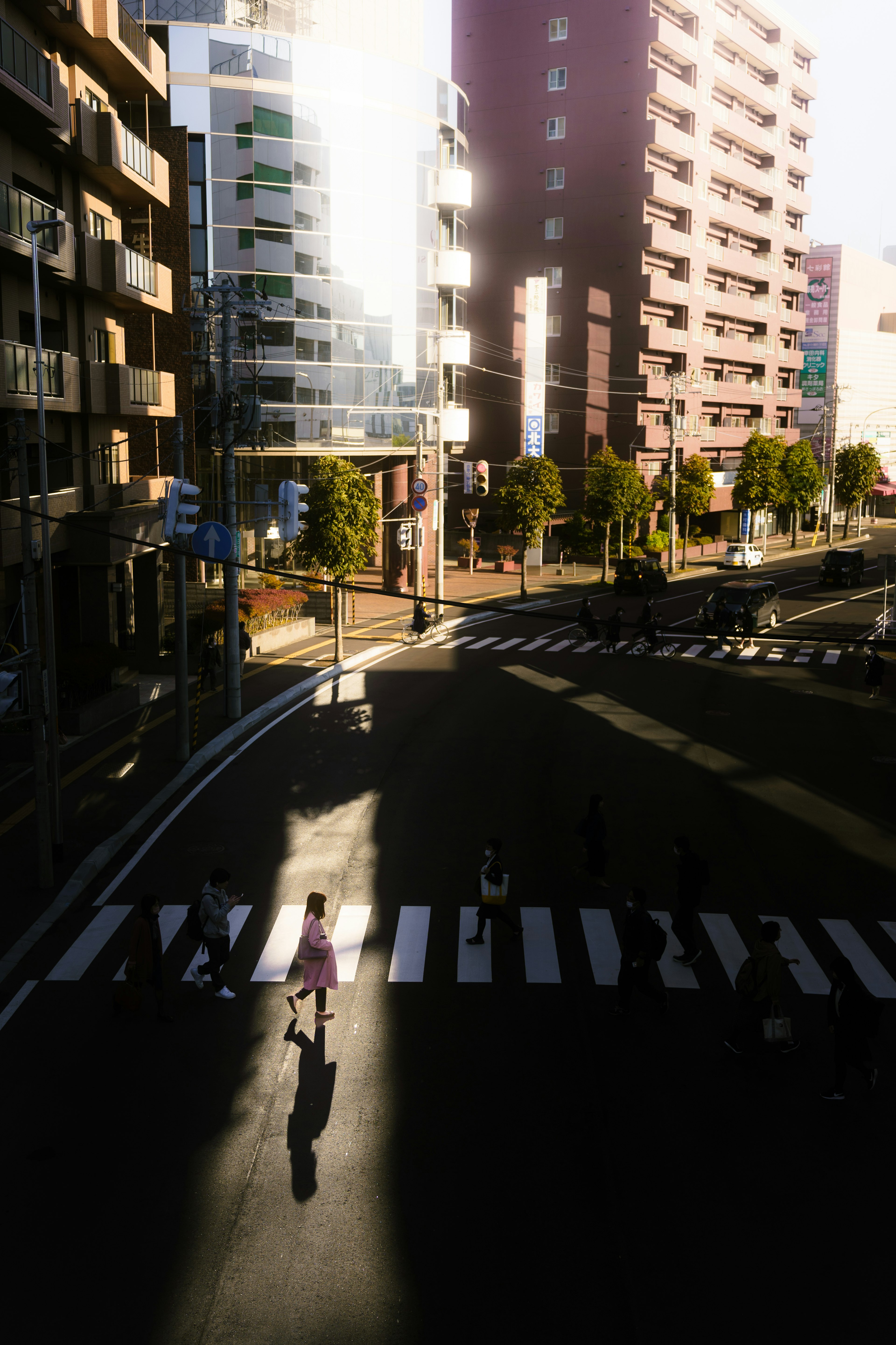 Silhouette d'une personne traversant une rue dans une intersection urbaine entourée de bâtiments