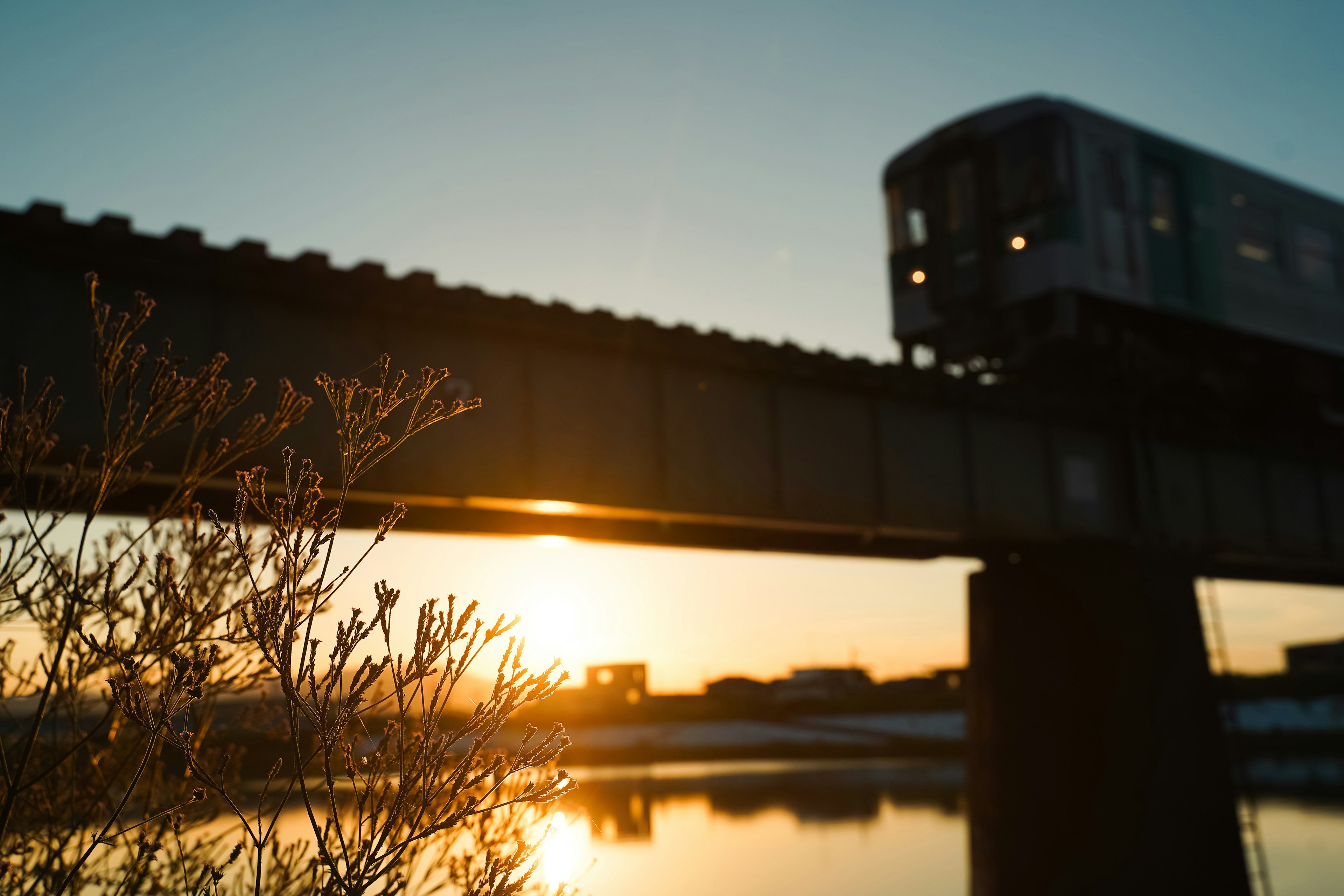 Silhouette eines Zuges auf einer Brücke gegen den Sonnenuntergang