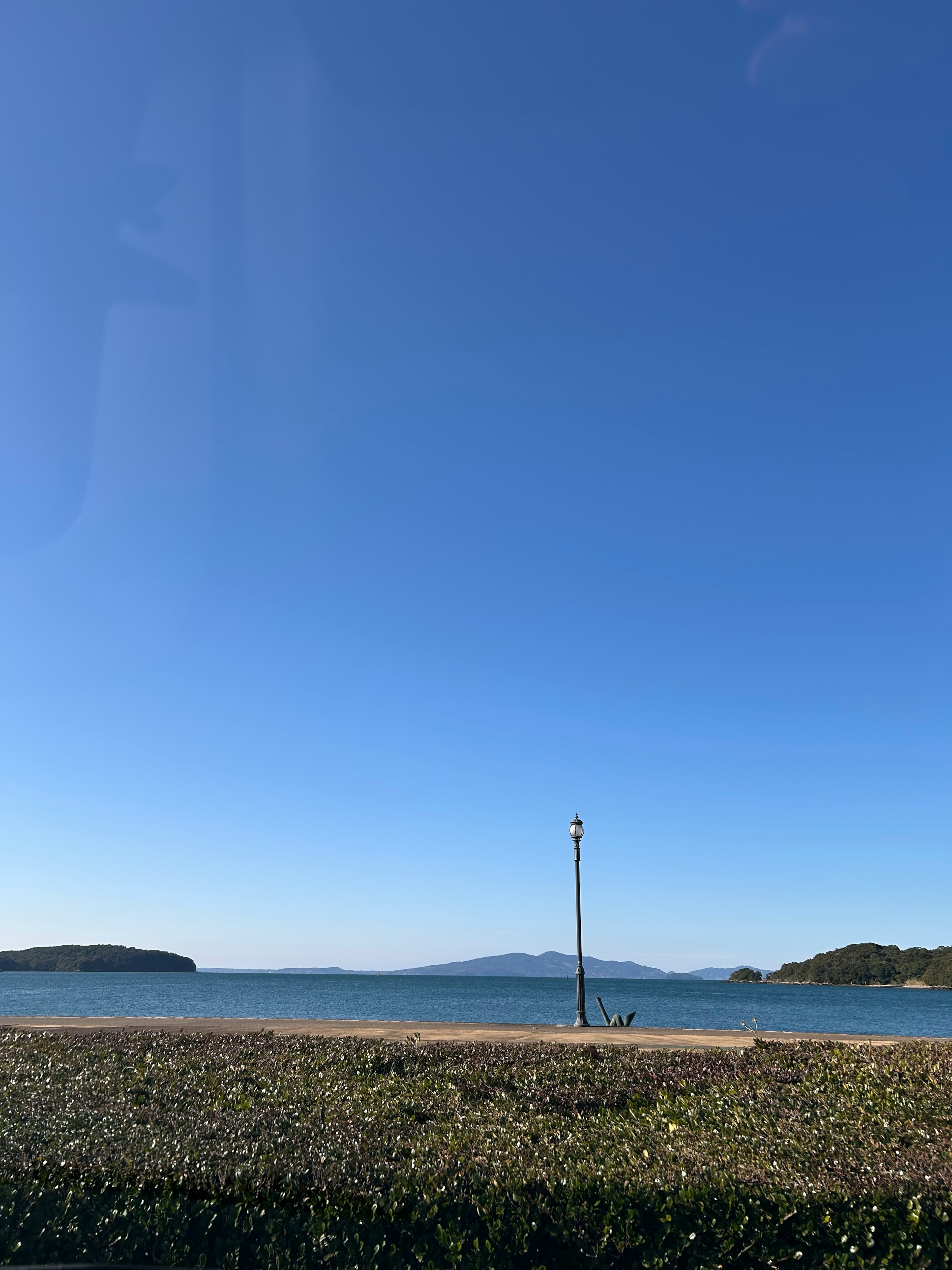 ท้องฟ้าสีฟ้าและวิวทะเลพร้อมชายหาดและเสาไฟ