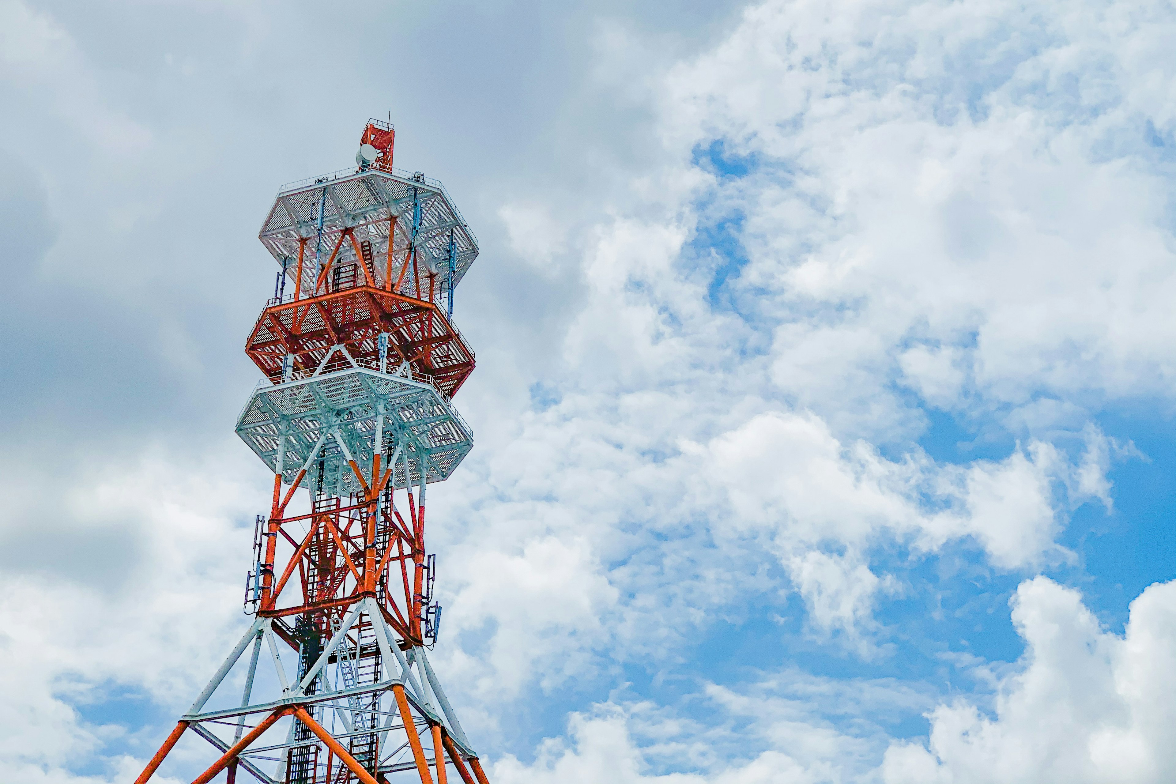 Image of a communication tower towering against a blue sky