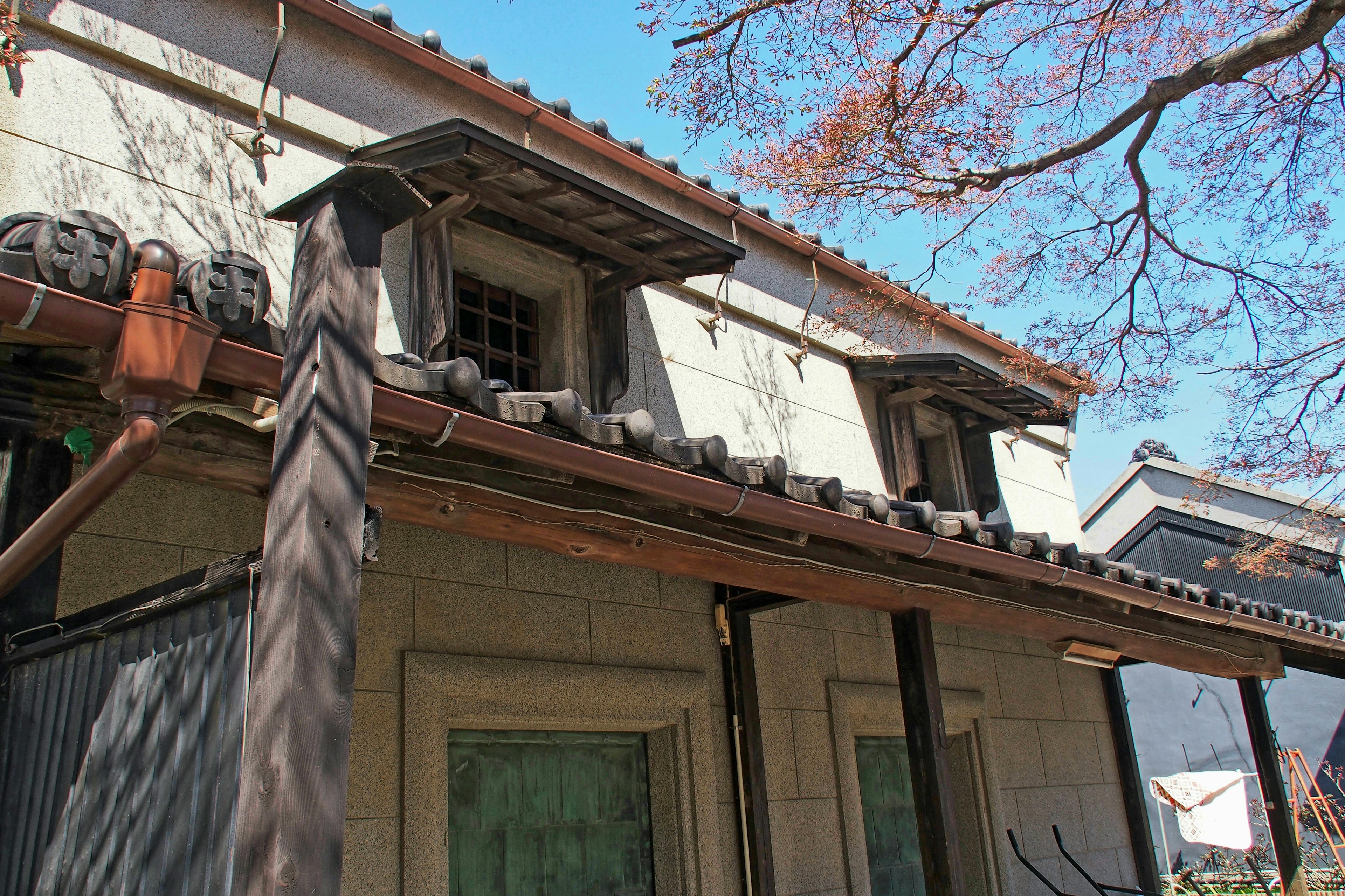 Traditional Japanese building exterior with wooden structure under blue sky