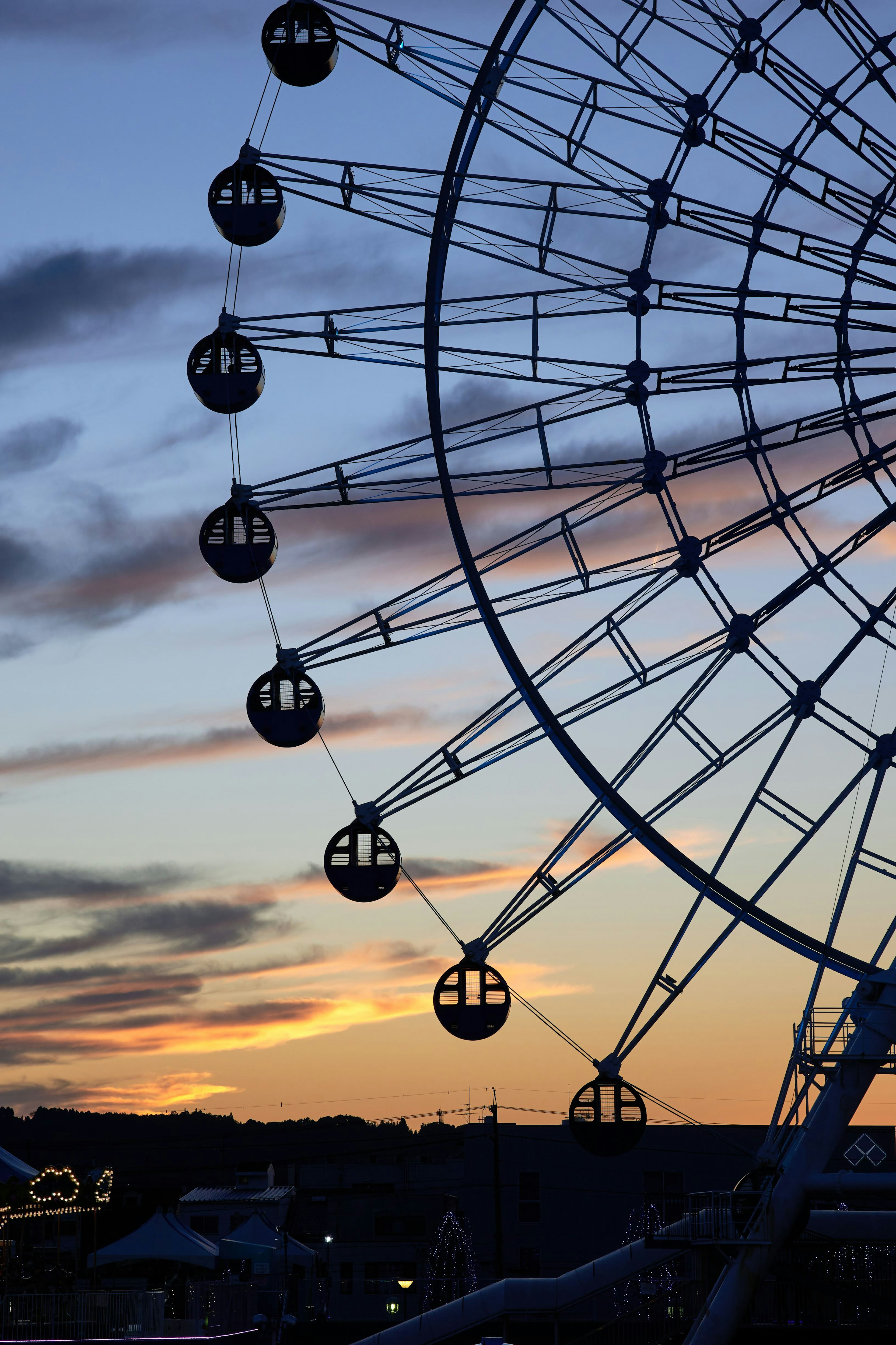 Silhouette of a Ferris wheel against a sunset