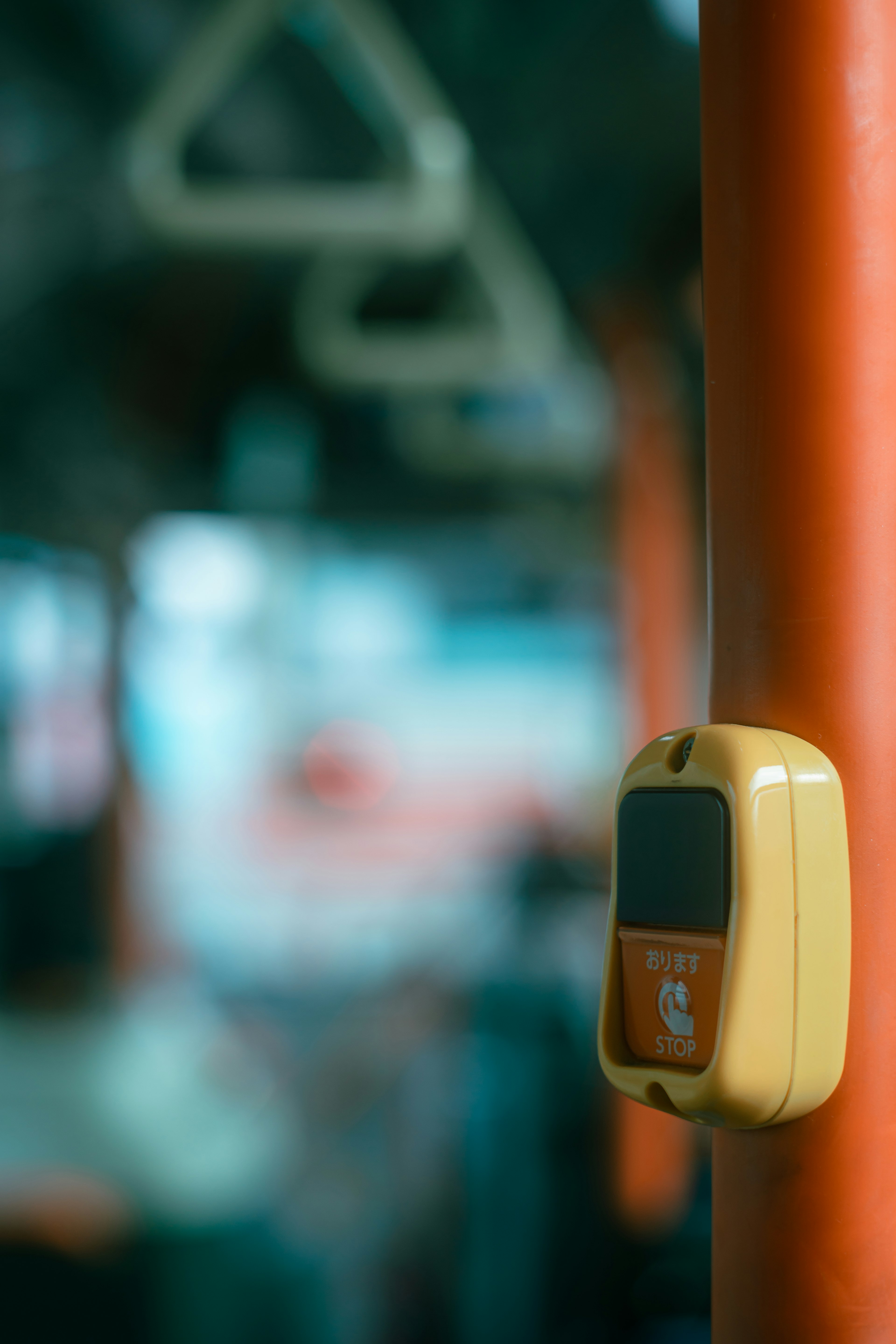 Primo piano di una macchina per pagamenti gialla e di un palo arancione all'interno di un autobus