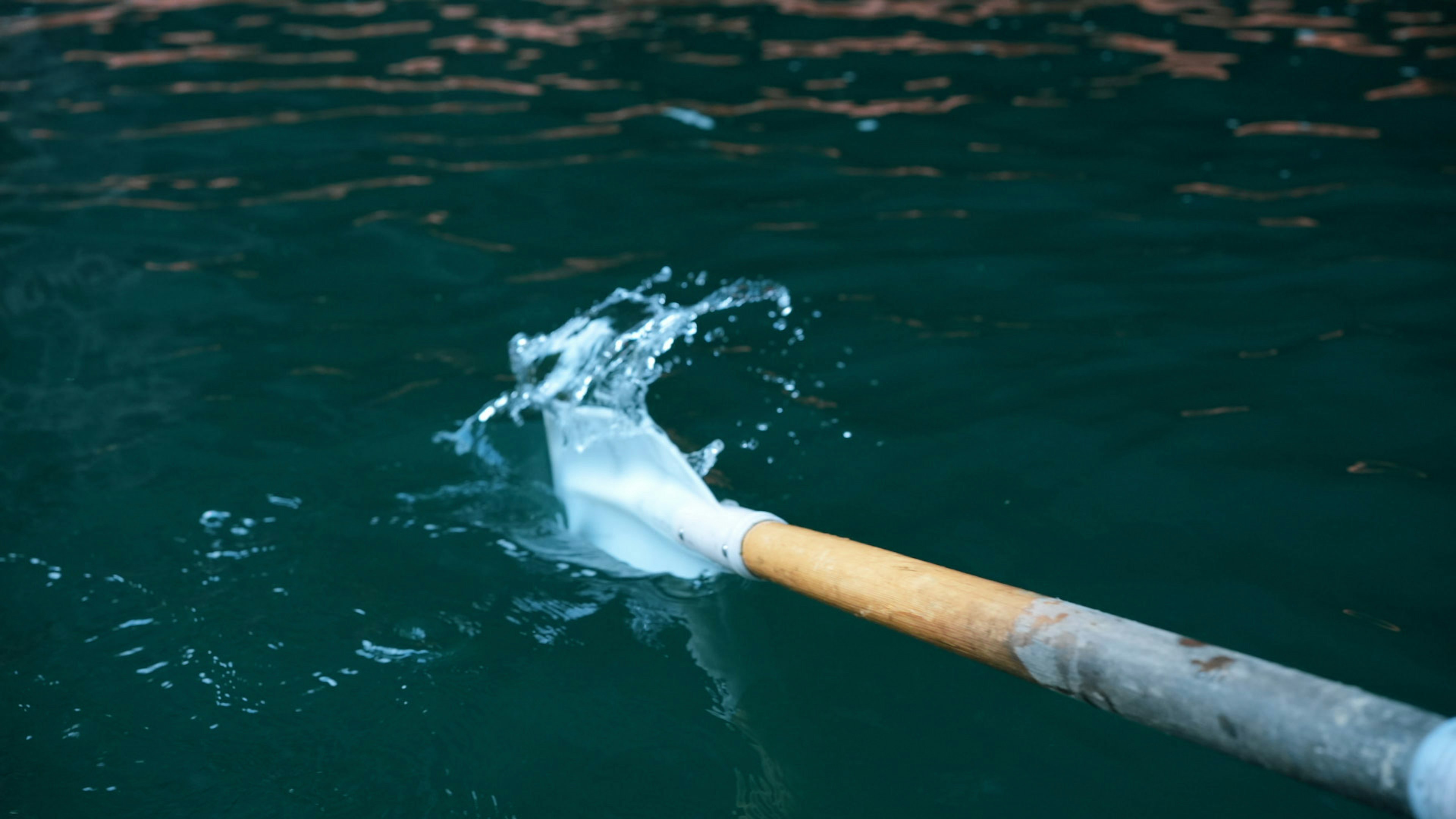 Ein Paddel, das die Wasseroberfläche mit Spritzern bricht