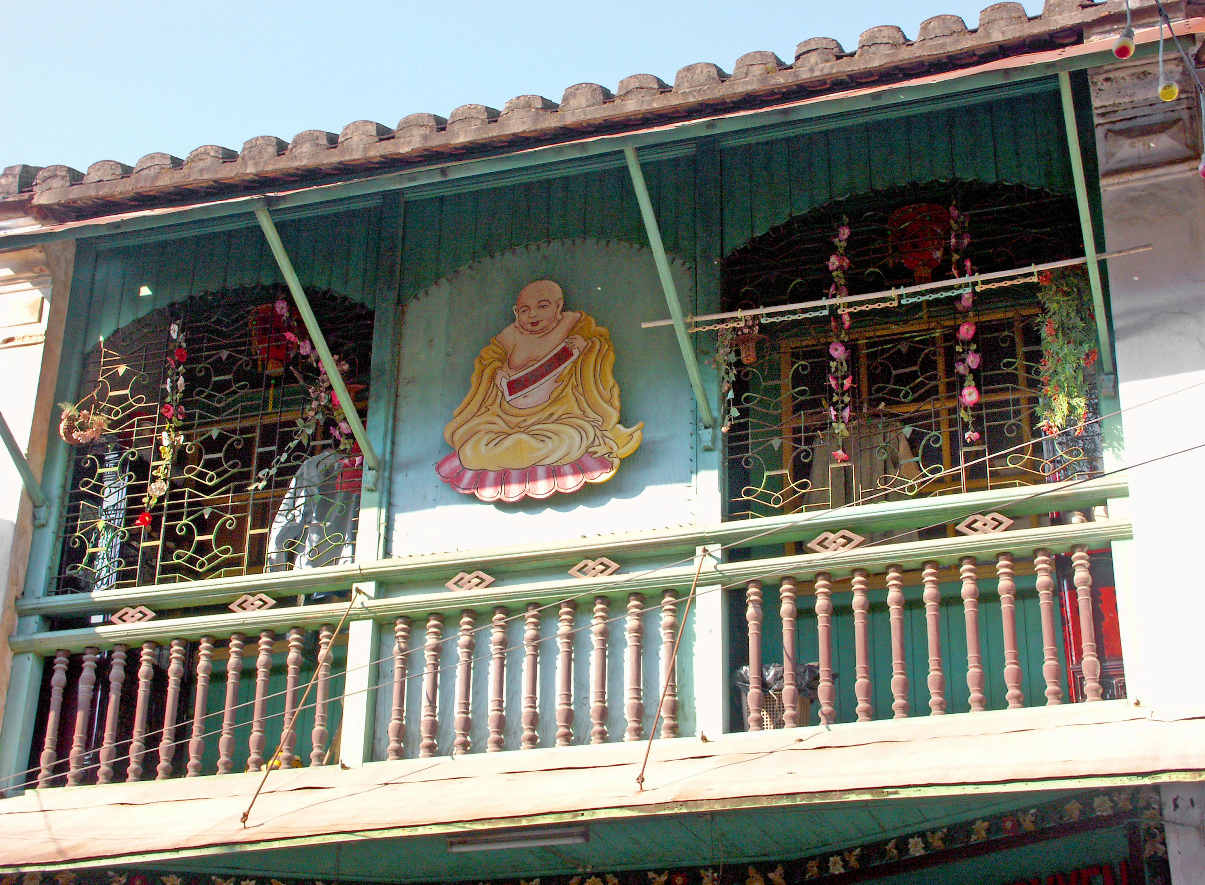 Bangunan tradisional dengan balkon dekoratif dan mural Buddha