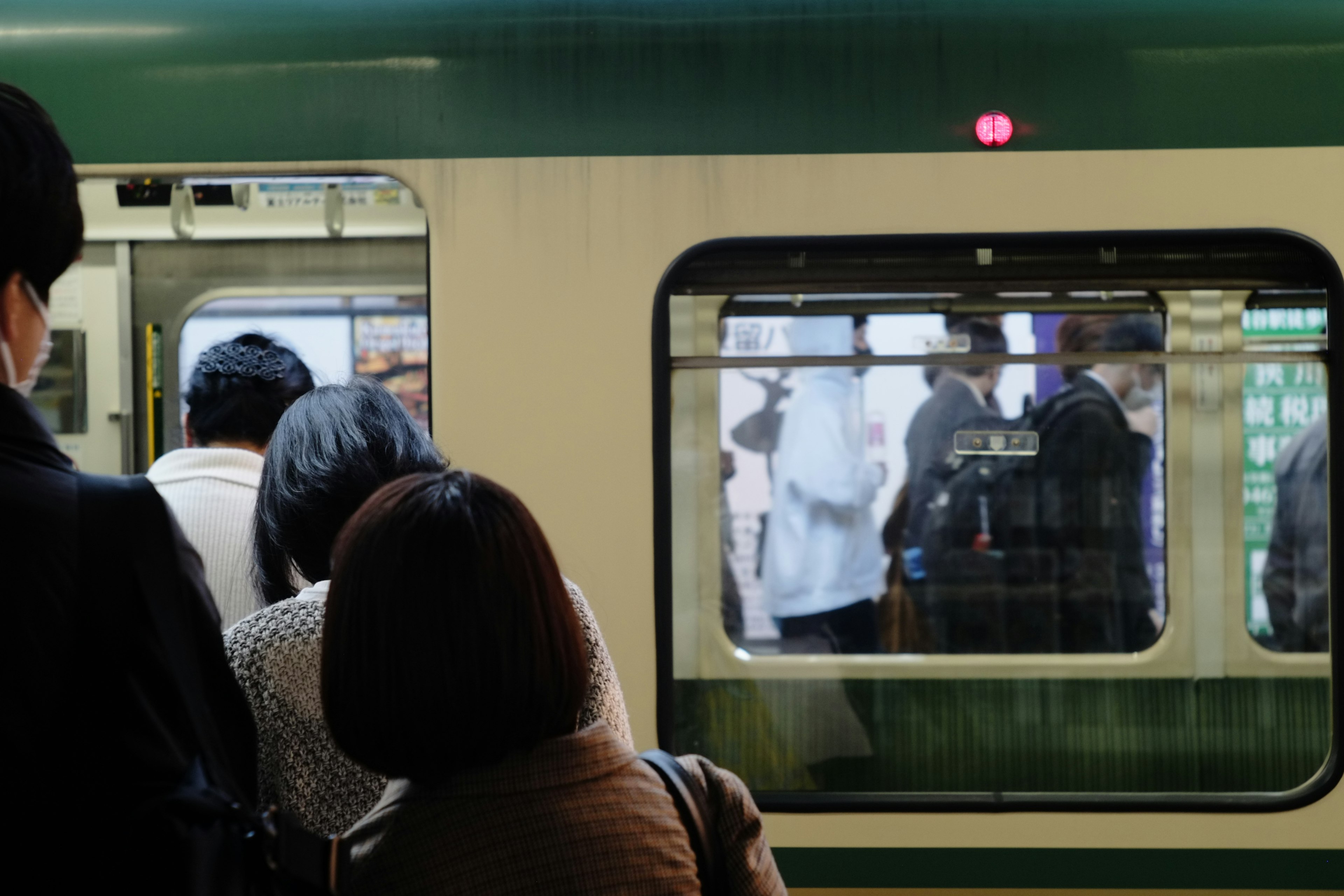 People waiting near a train door with the interior visible