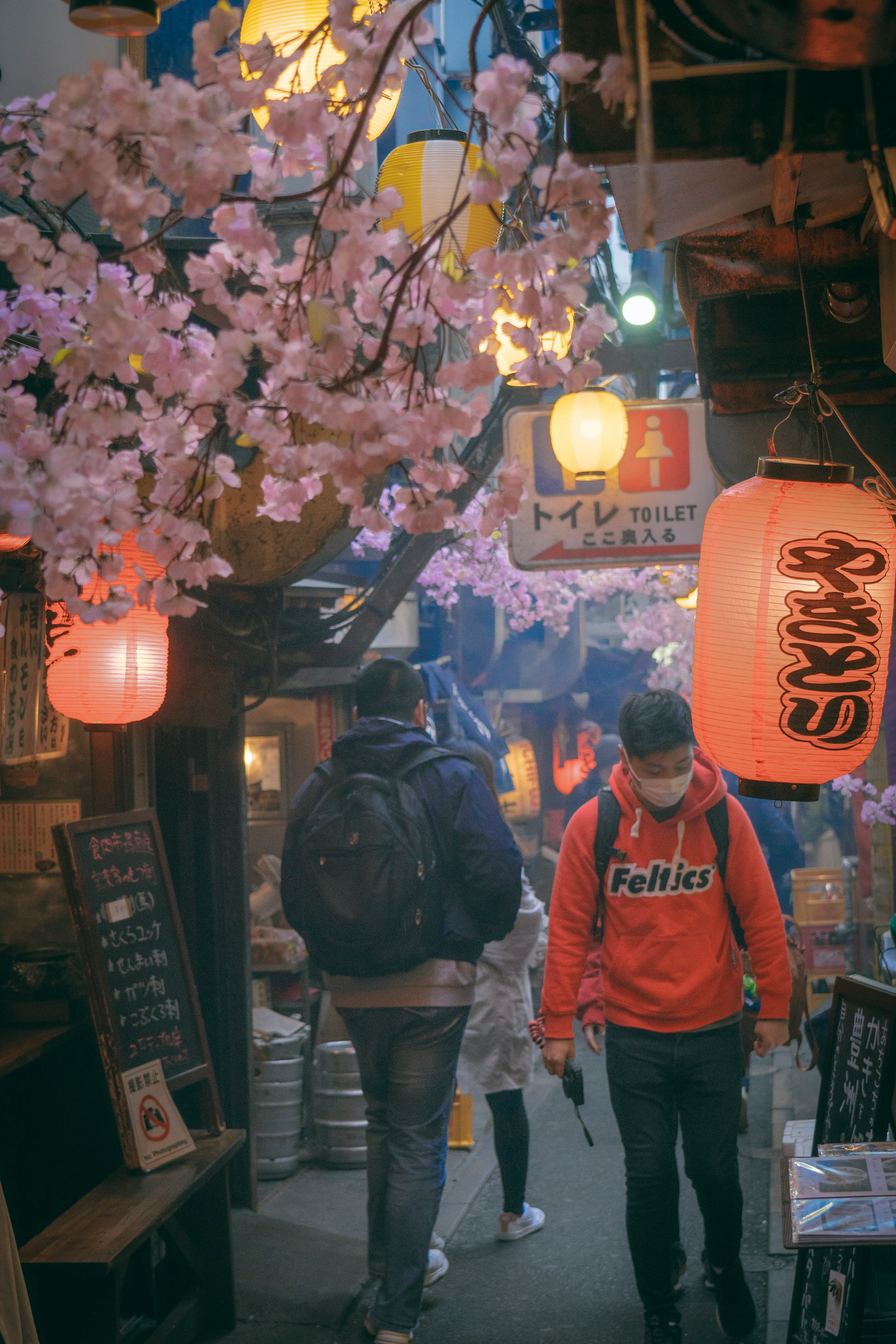 桜の花が装飾された日本の街並みを歩く人々の風景