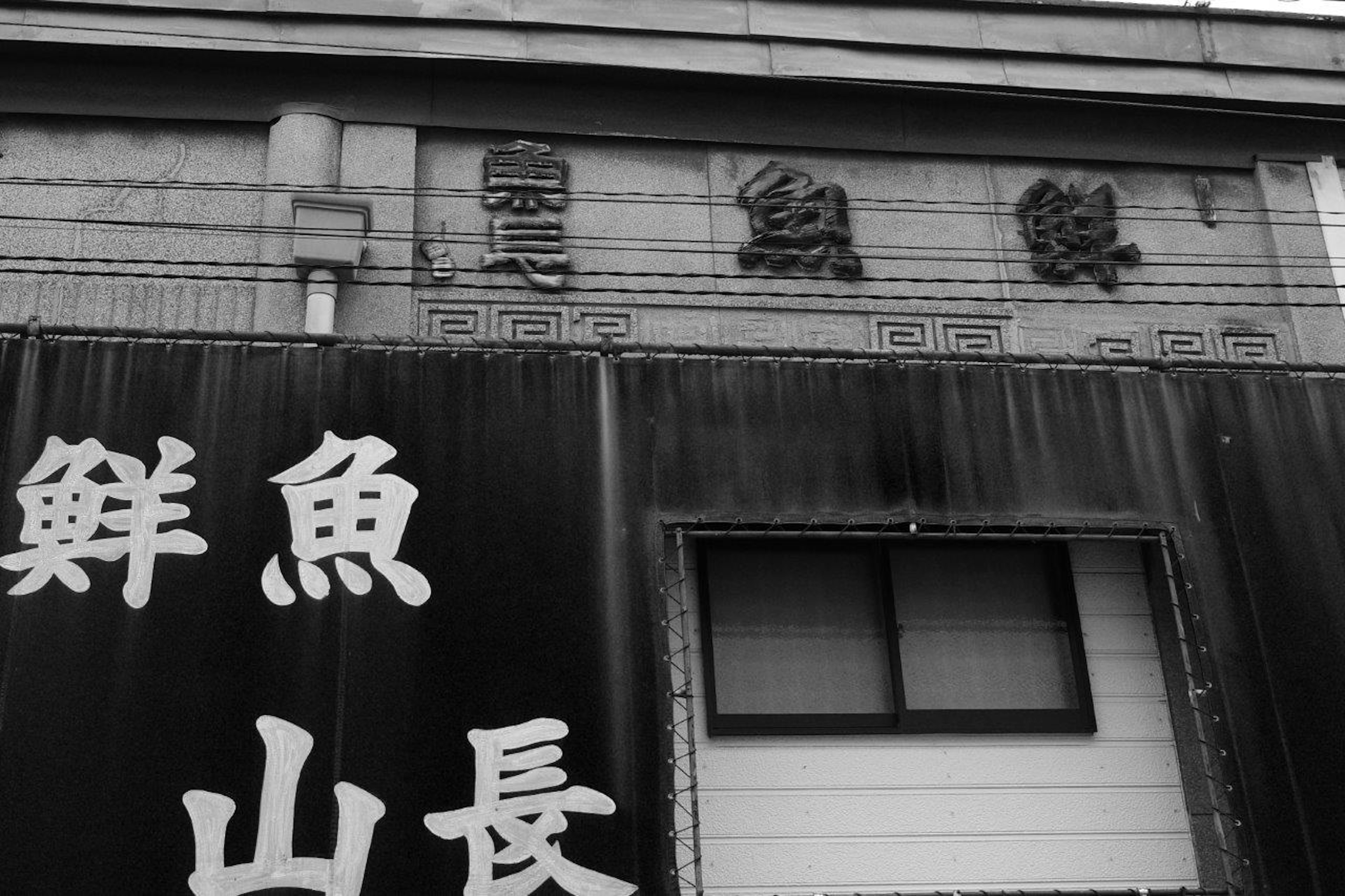 Panneau noir et blanc avec des caractères de poisson frais et des caractères Yamaguchi