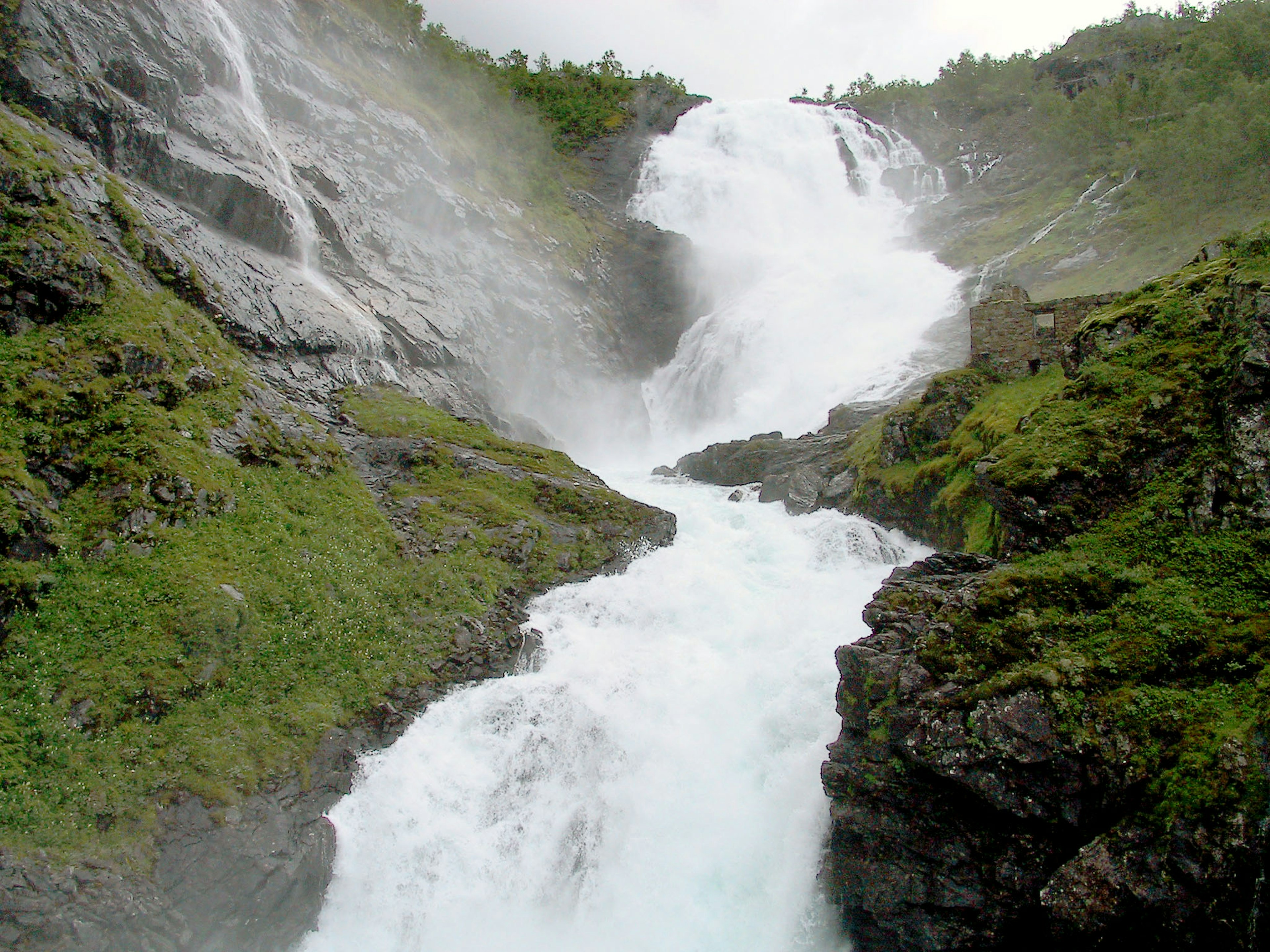 Mächtiger Wasserfall, der von felsigen Klippen mit üppigem Grün umgeben ist