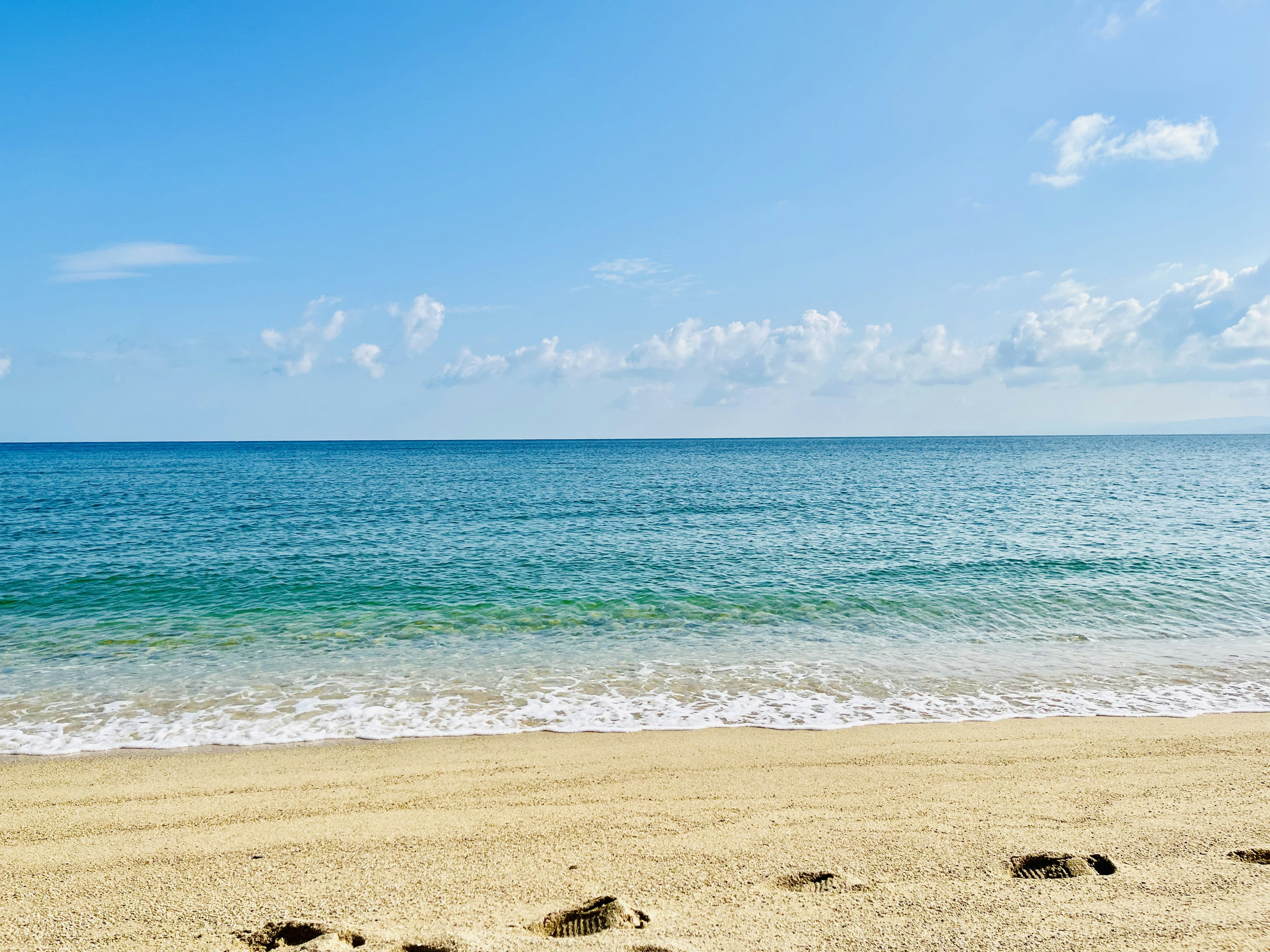 Vista escénica del mar azul y la playa de arena