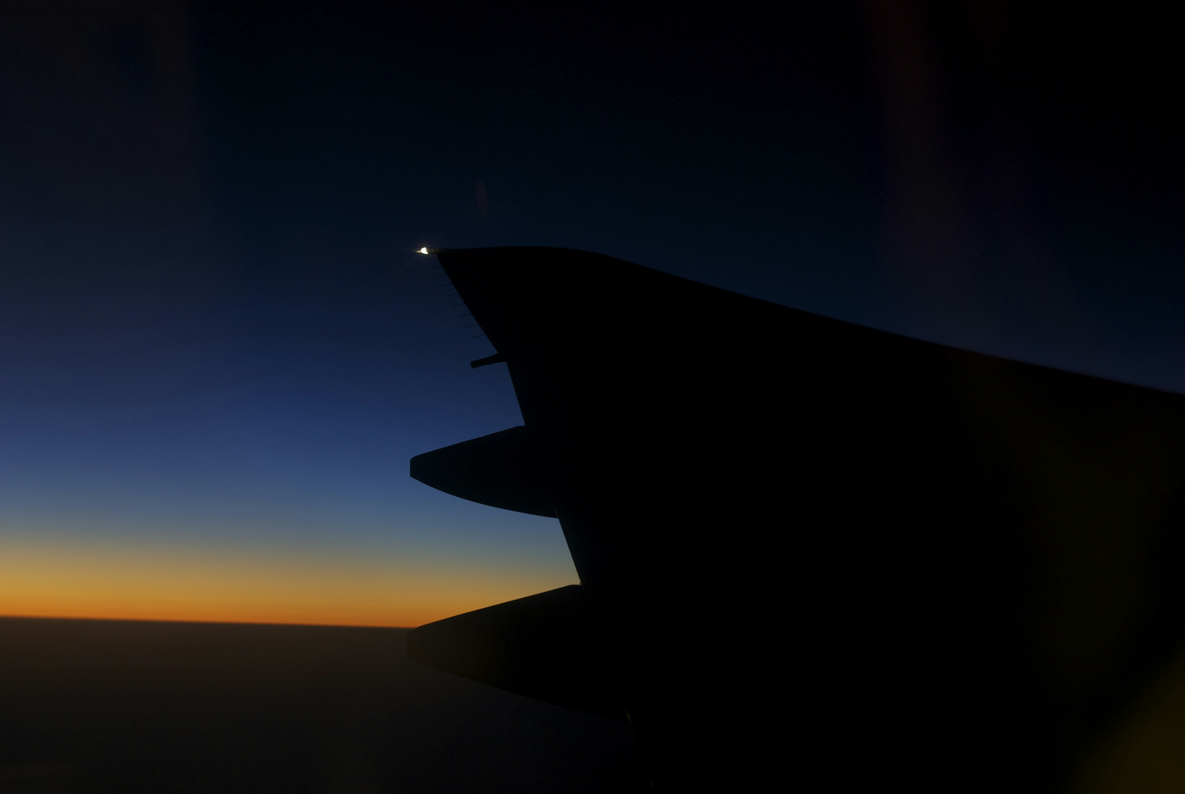 Silhouette of an aircraft wing against a twilight sky