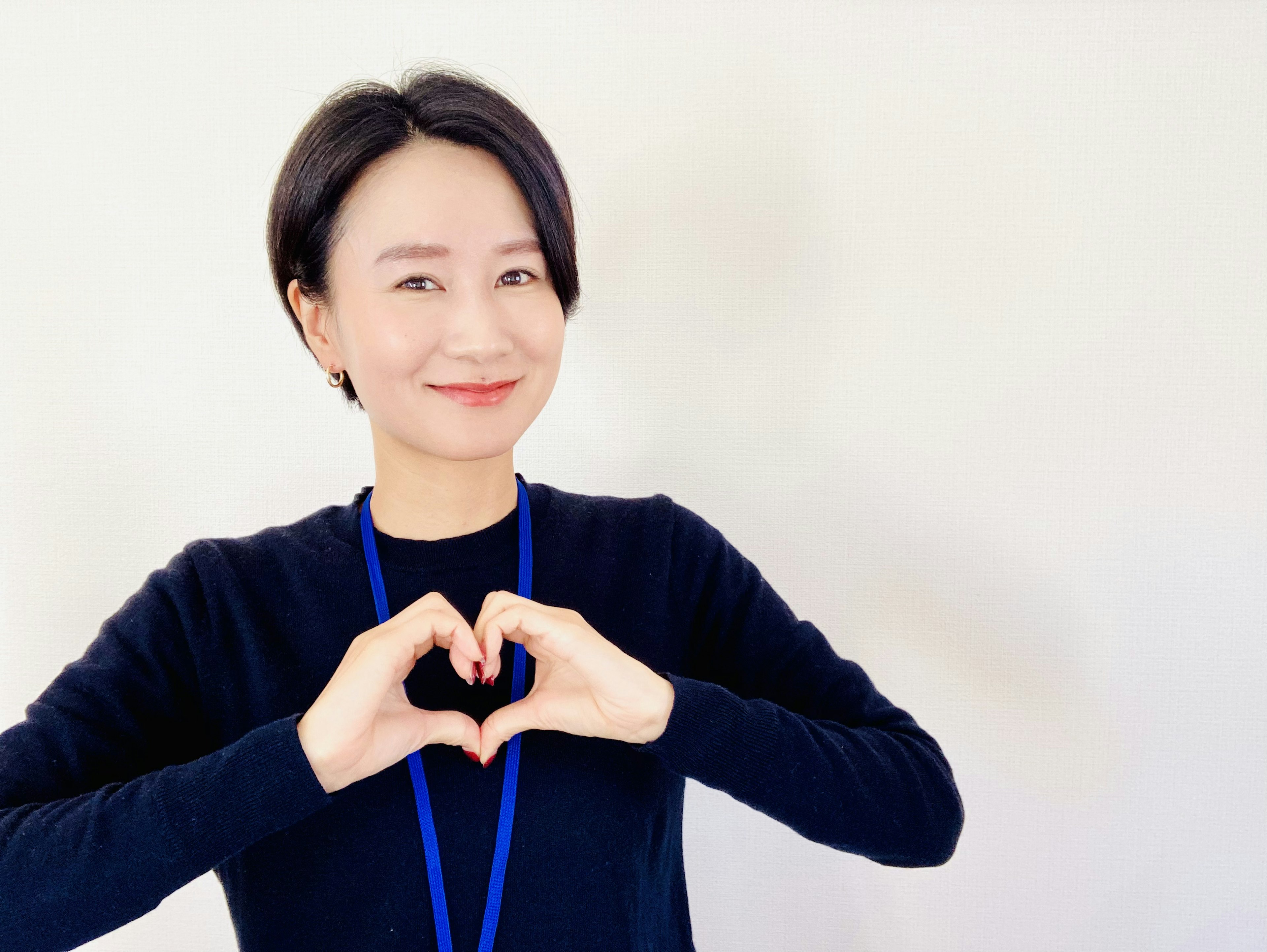 Woman making a heart shape with her hands and smiling