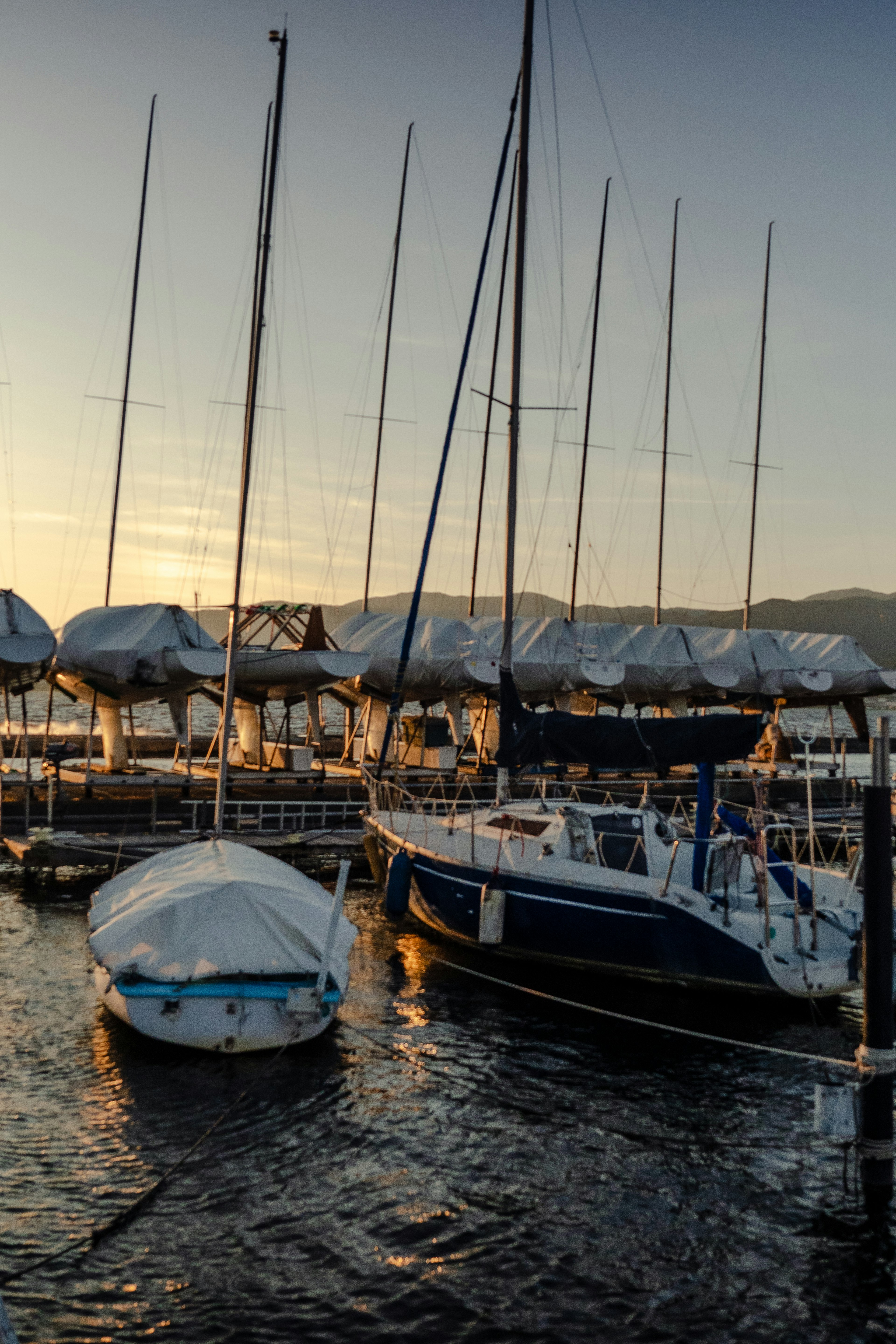 A scenic view of yachts and boats docked with a sunset backdrop