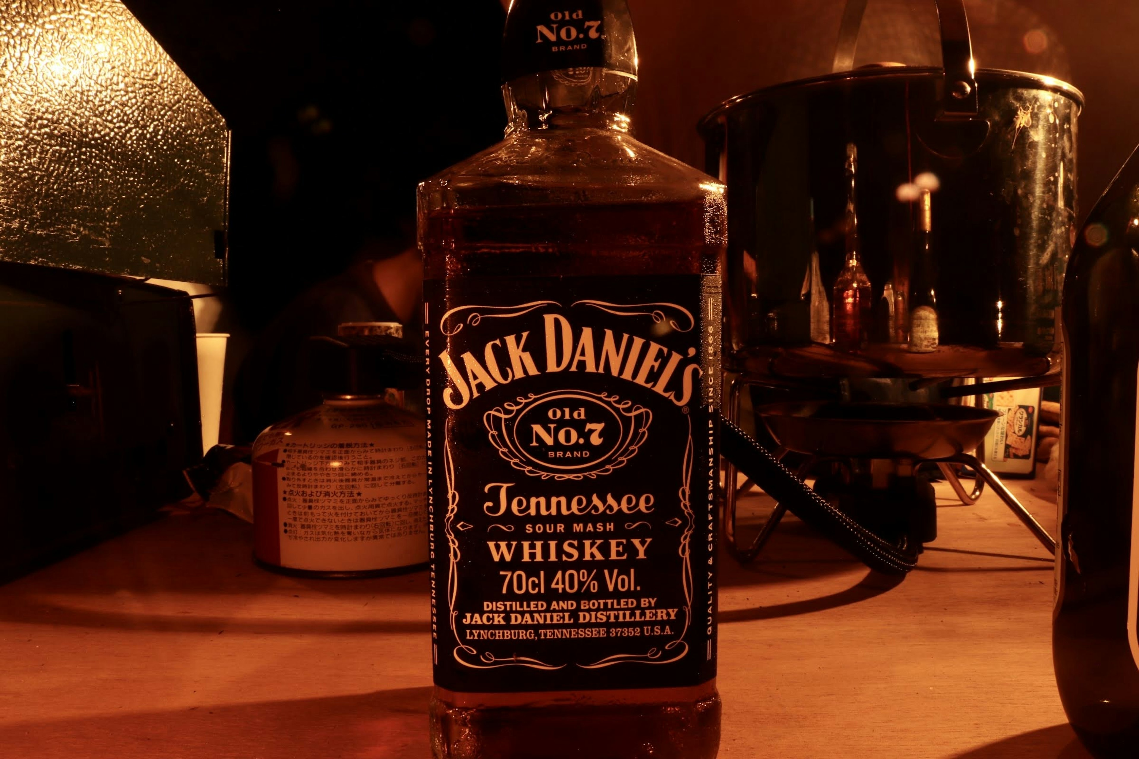 Botella de whiskey Jack Daniel's iluminada contra un fondo oscuro