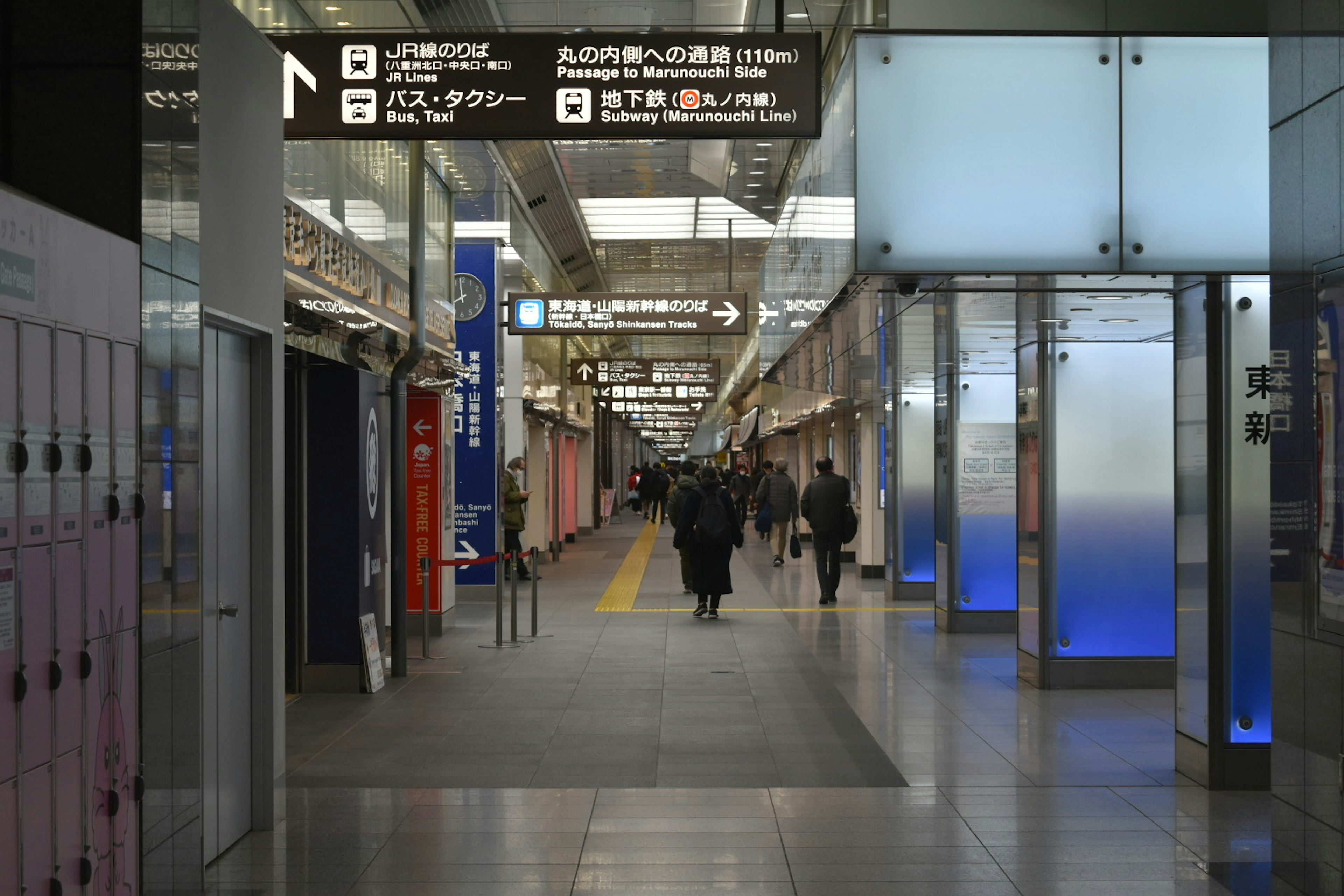 Lorong dalam stasiun kereta dengan orang-orang yang berjalan Pencahayaan cerah dan desain arsitektur modern