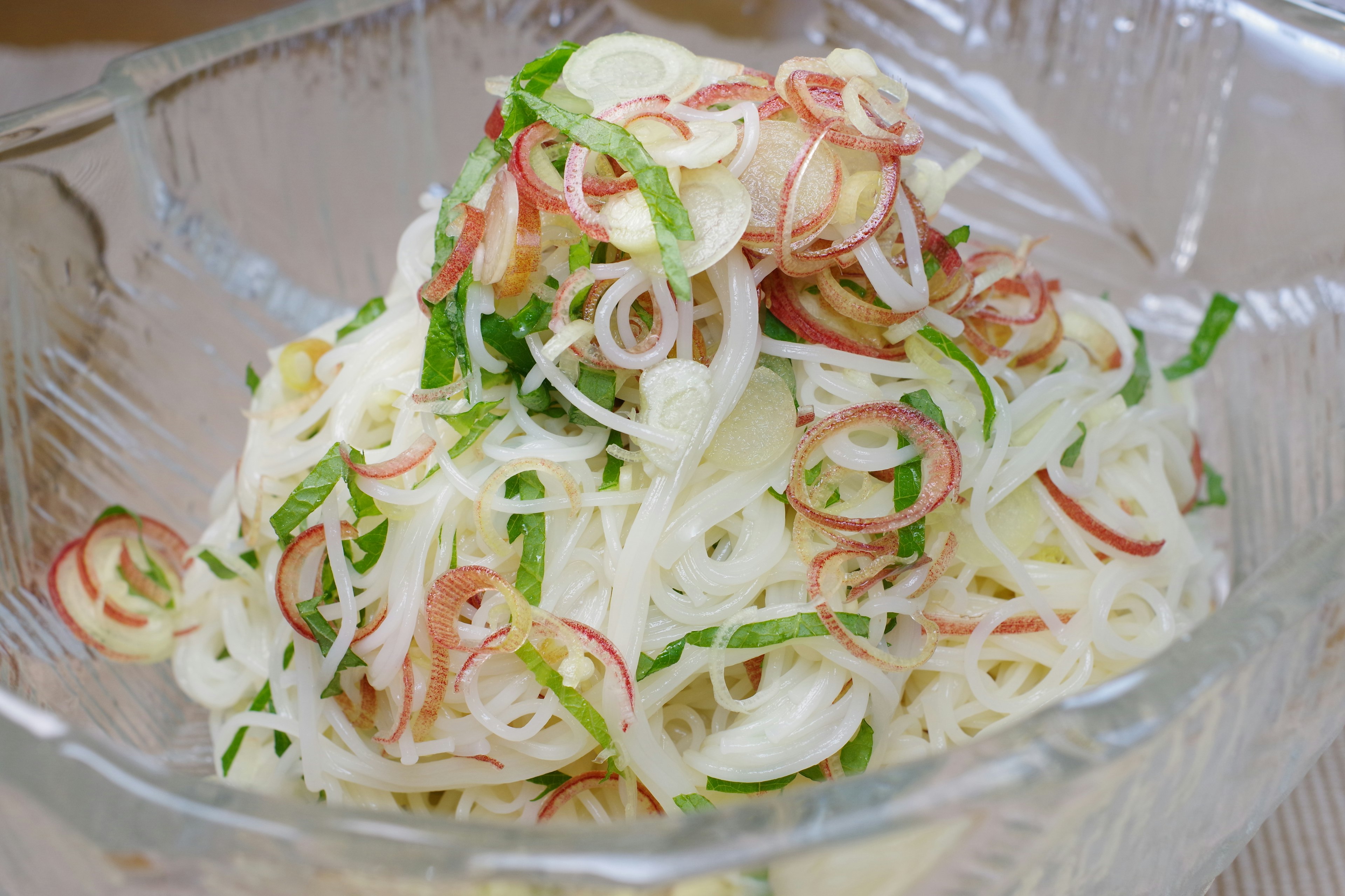 Imagen de ensalada de fideos de arroz finos servida en un tazón transparente