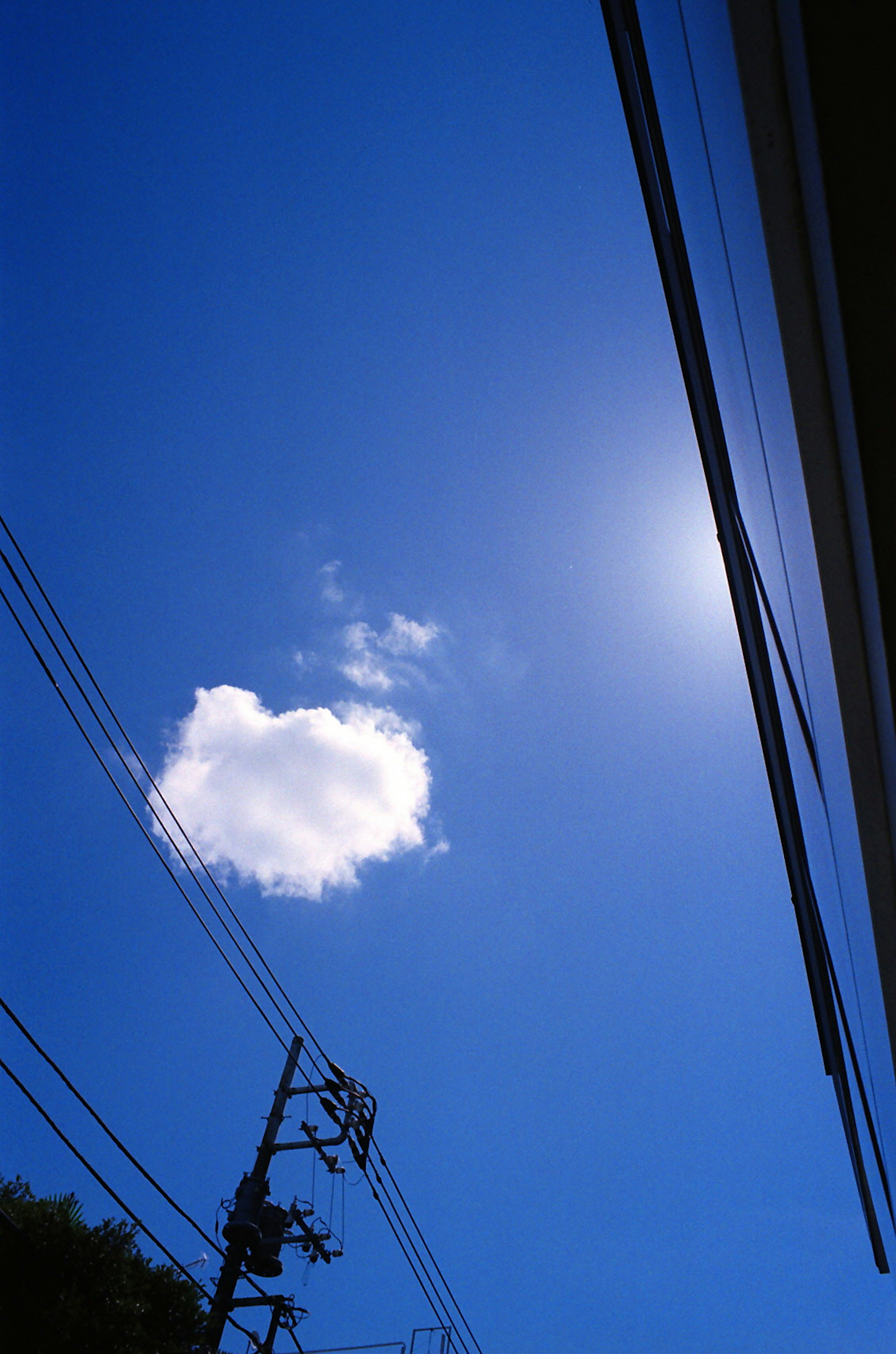 Ein klarer blauer Himmel mit einer weißen Wolke und Sonnenlicht