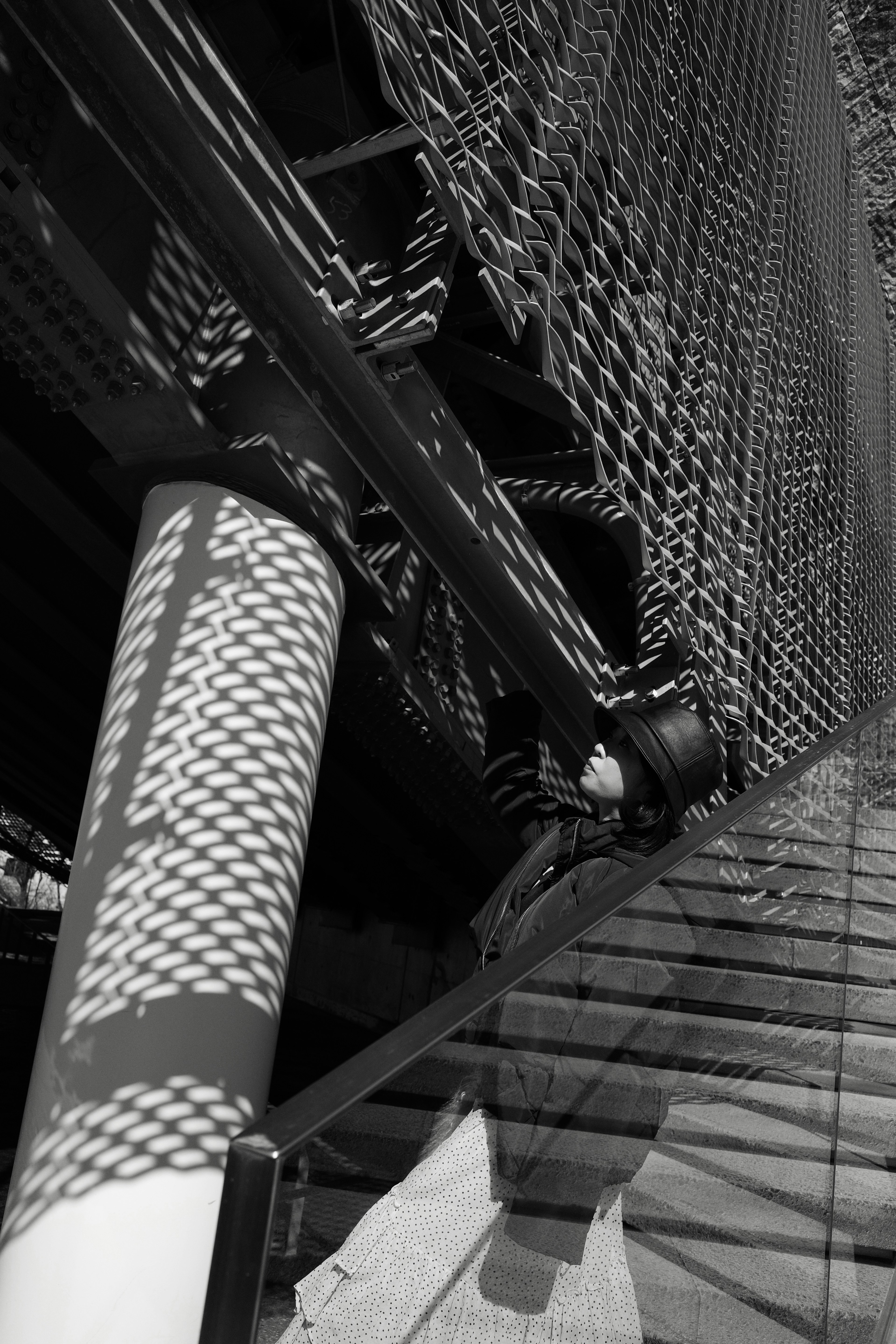 Imagen en blanco y negro que presenta escaleras y detalles de estructura de malla