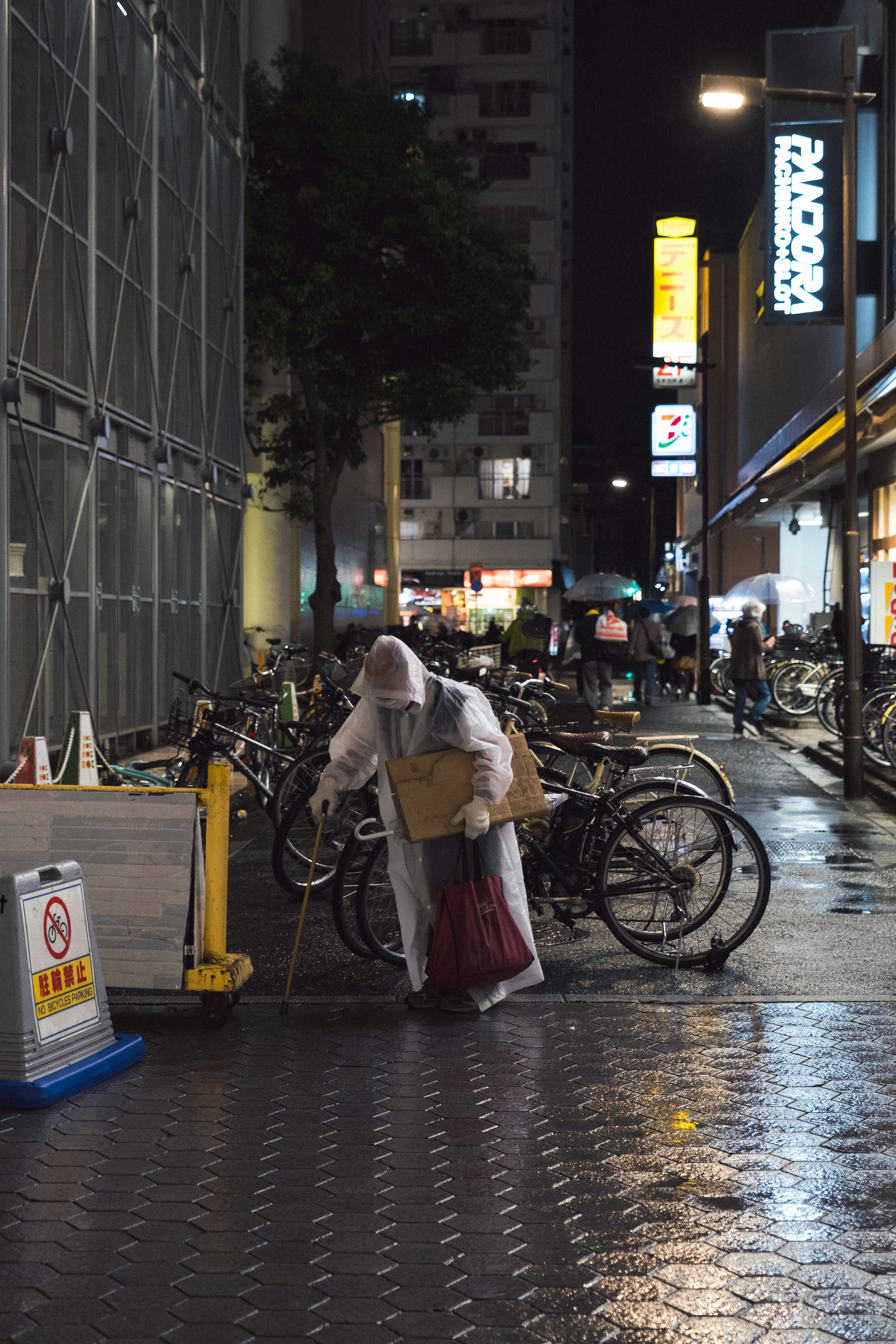 夜の街角で自転車の近くに立つ白い衣装の人物