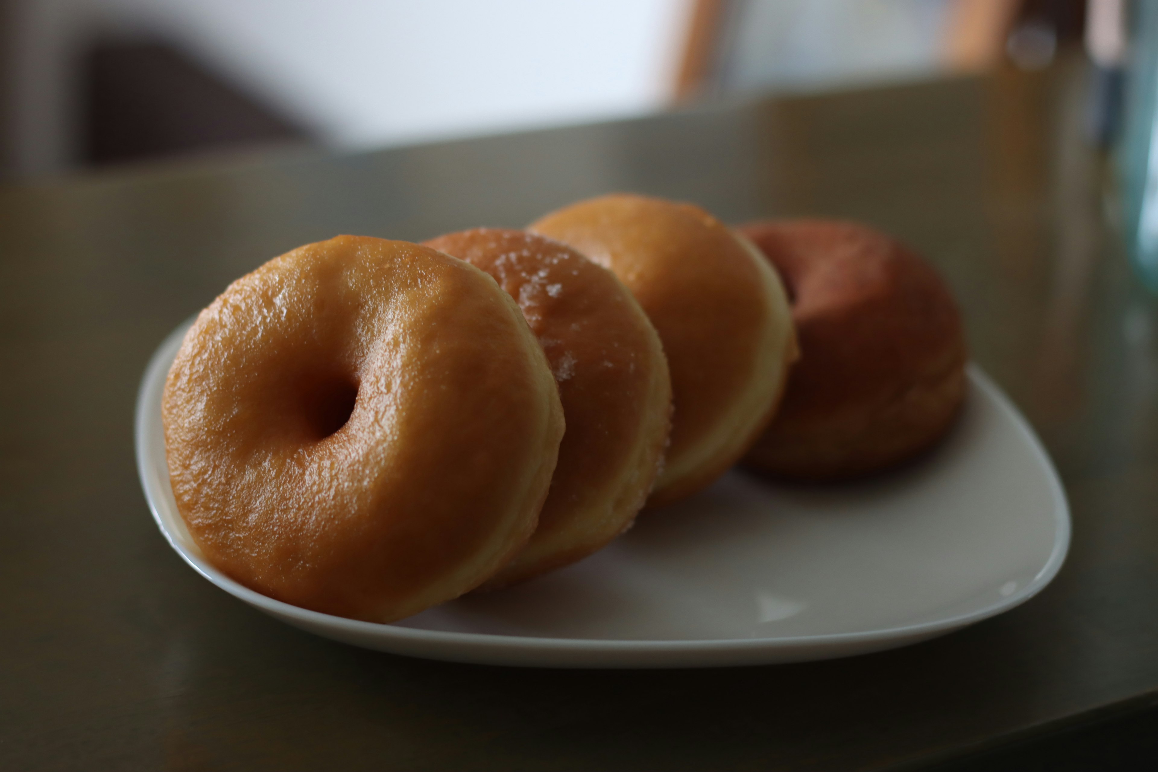 Ba chiếc bánh donut trên đĩa với bề mặt giòn và kết cấu mềm mại