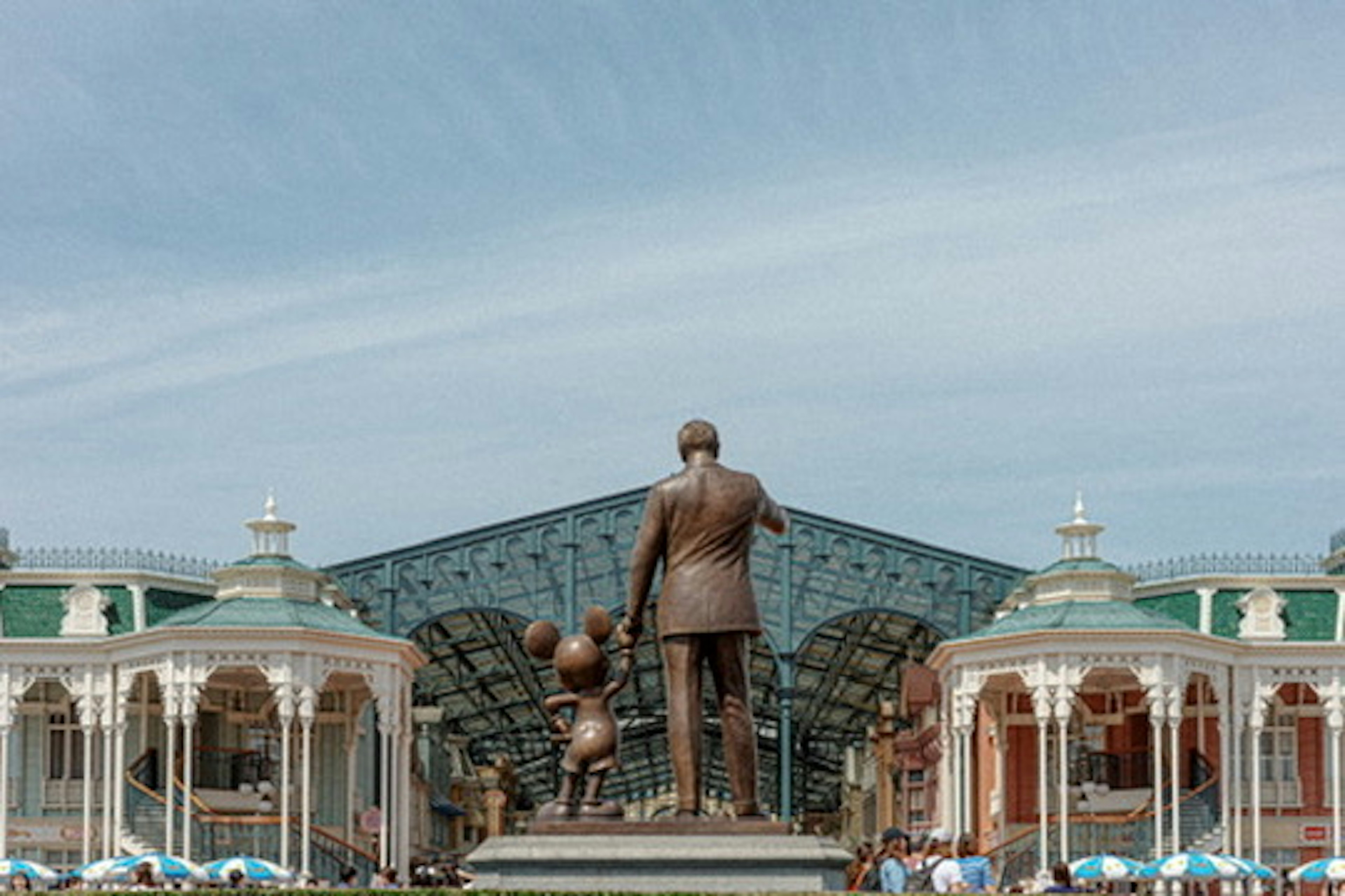 Statue von Walt Disney und Mickey Mouse vor einem Disney-Parkgebäude