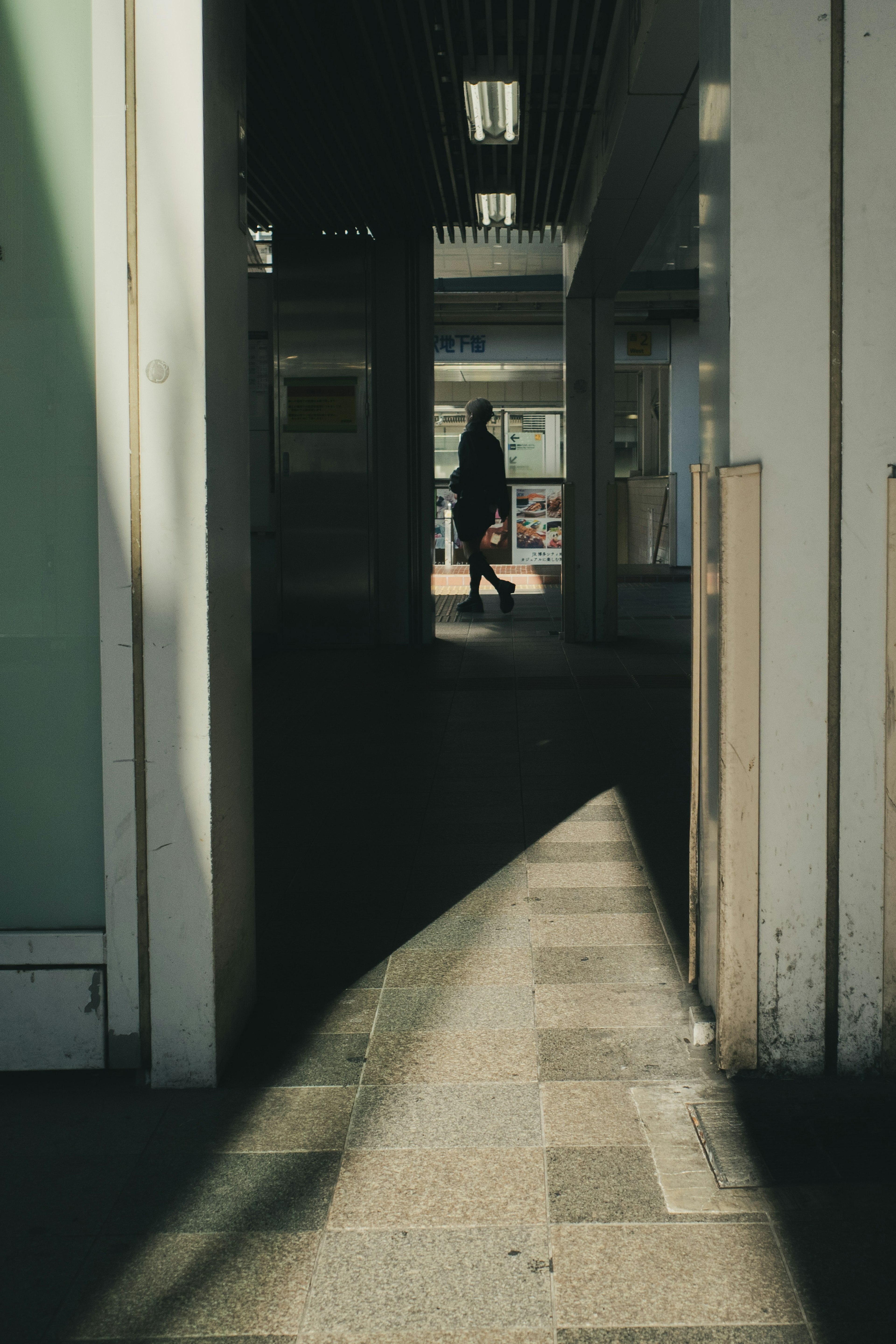 Silhouette einer Person in einem Flur mit langen Schatten