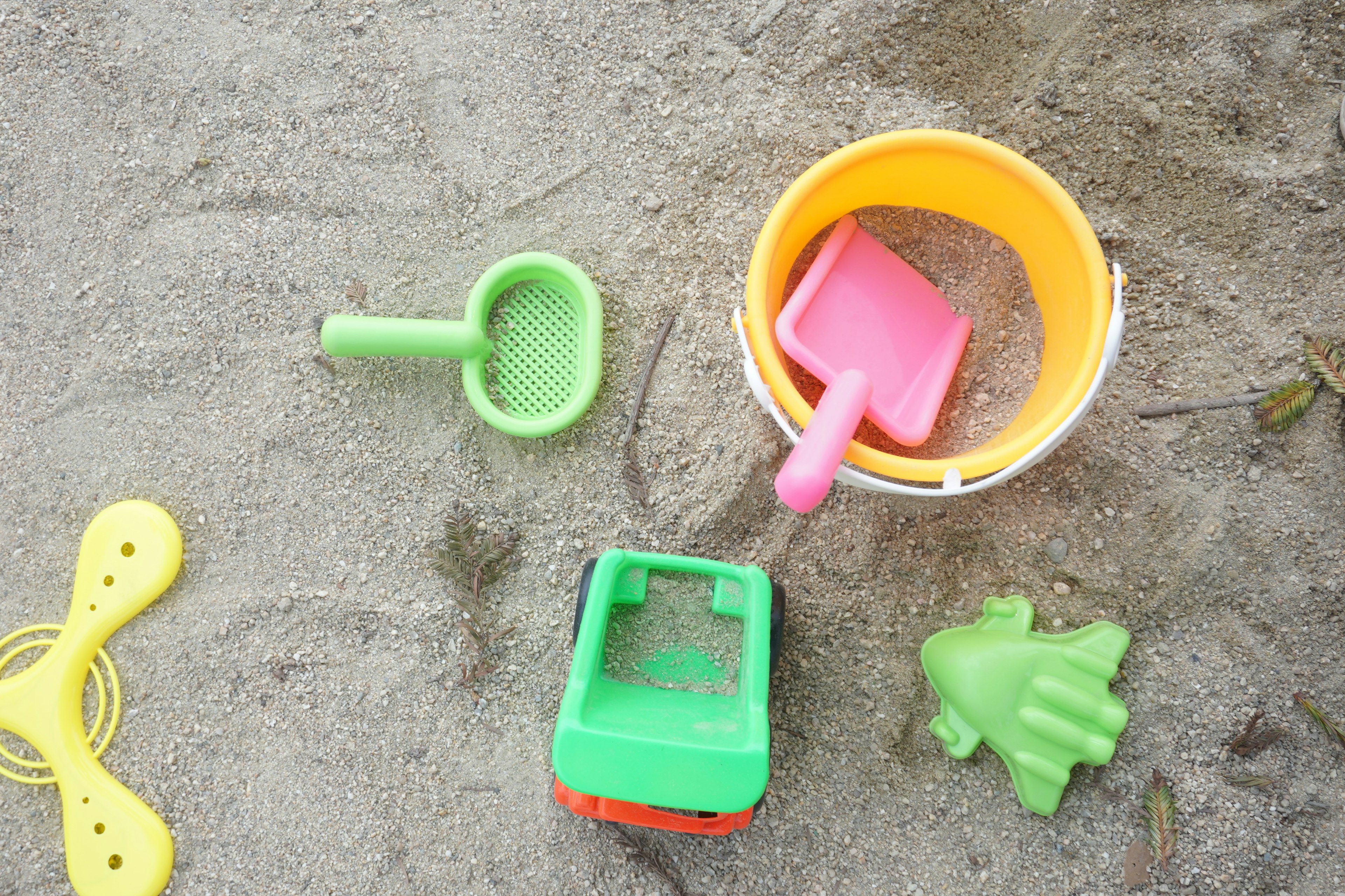 Colorful set of sand toys arranged on the sand