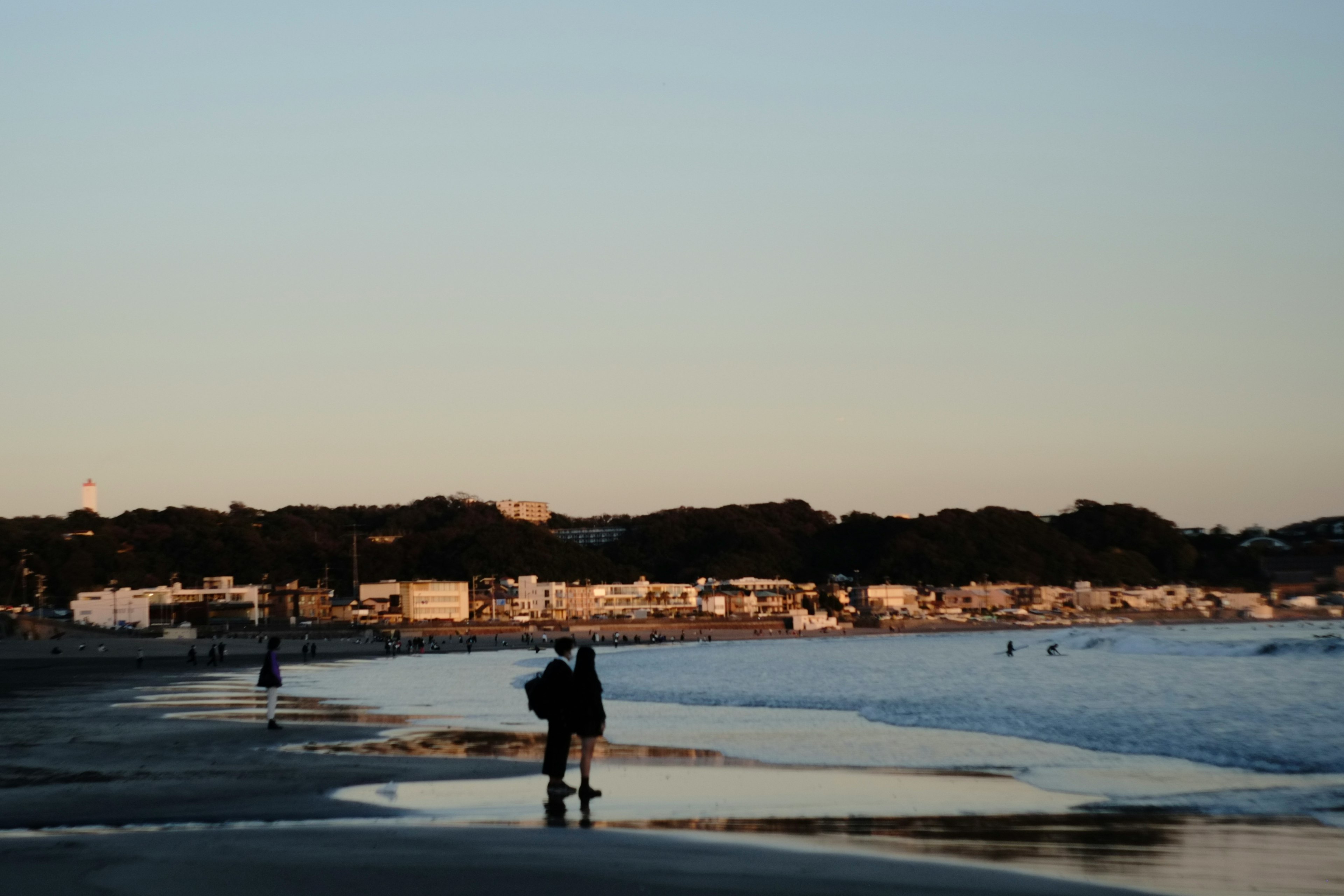 夕暮れのビーチで人が立っている風景