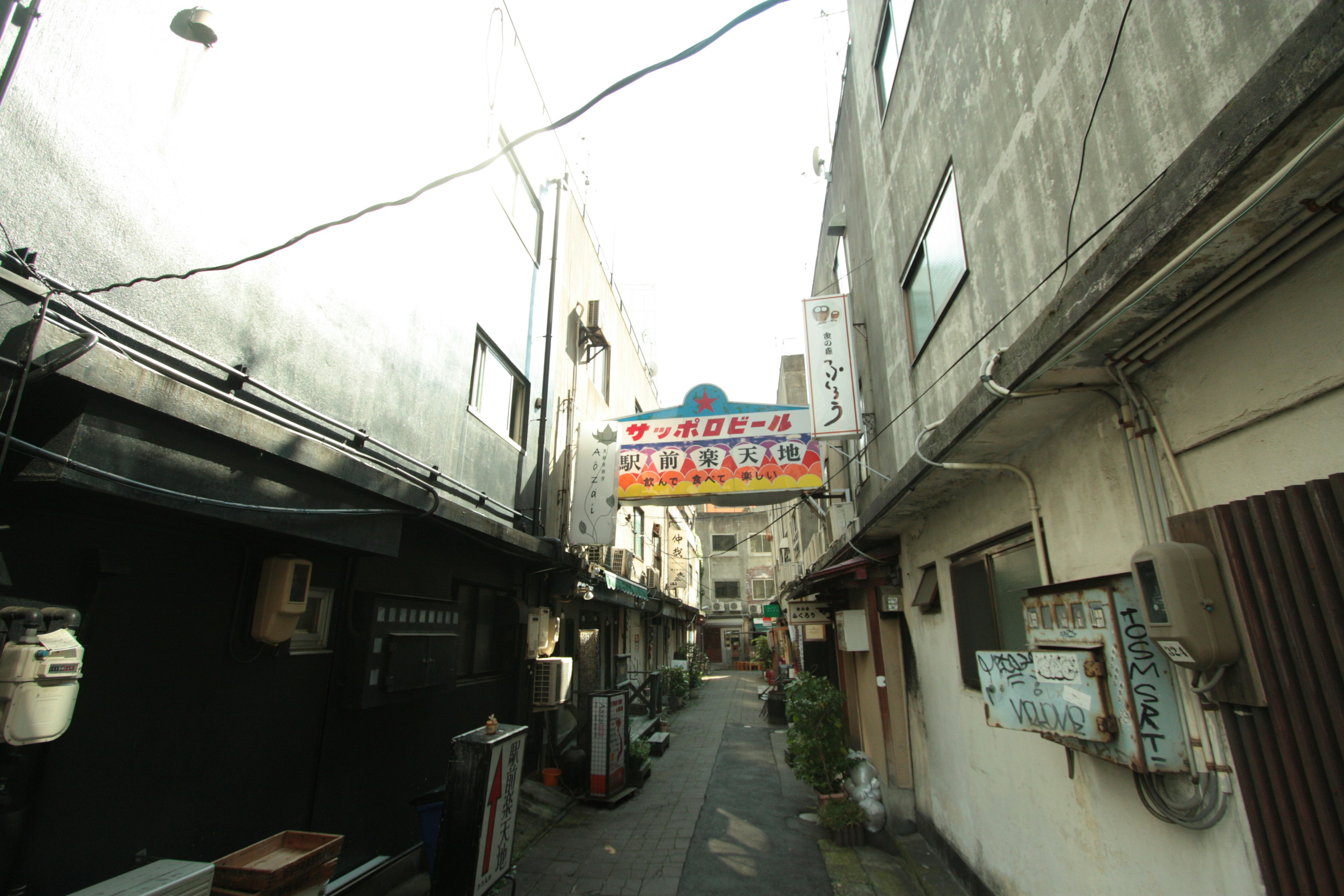 Callejón estrecho con edificios antiguos y un cartel colorido