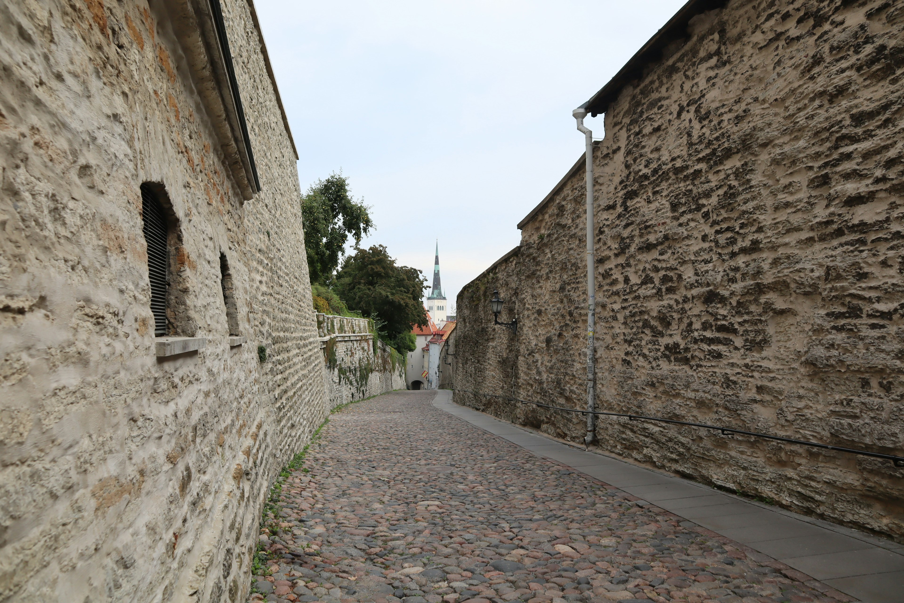 Foto von einer gepflasterten Gasse, umgeben von Steinmauern