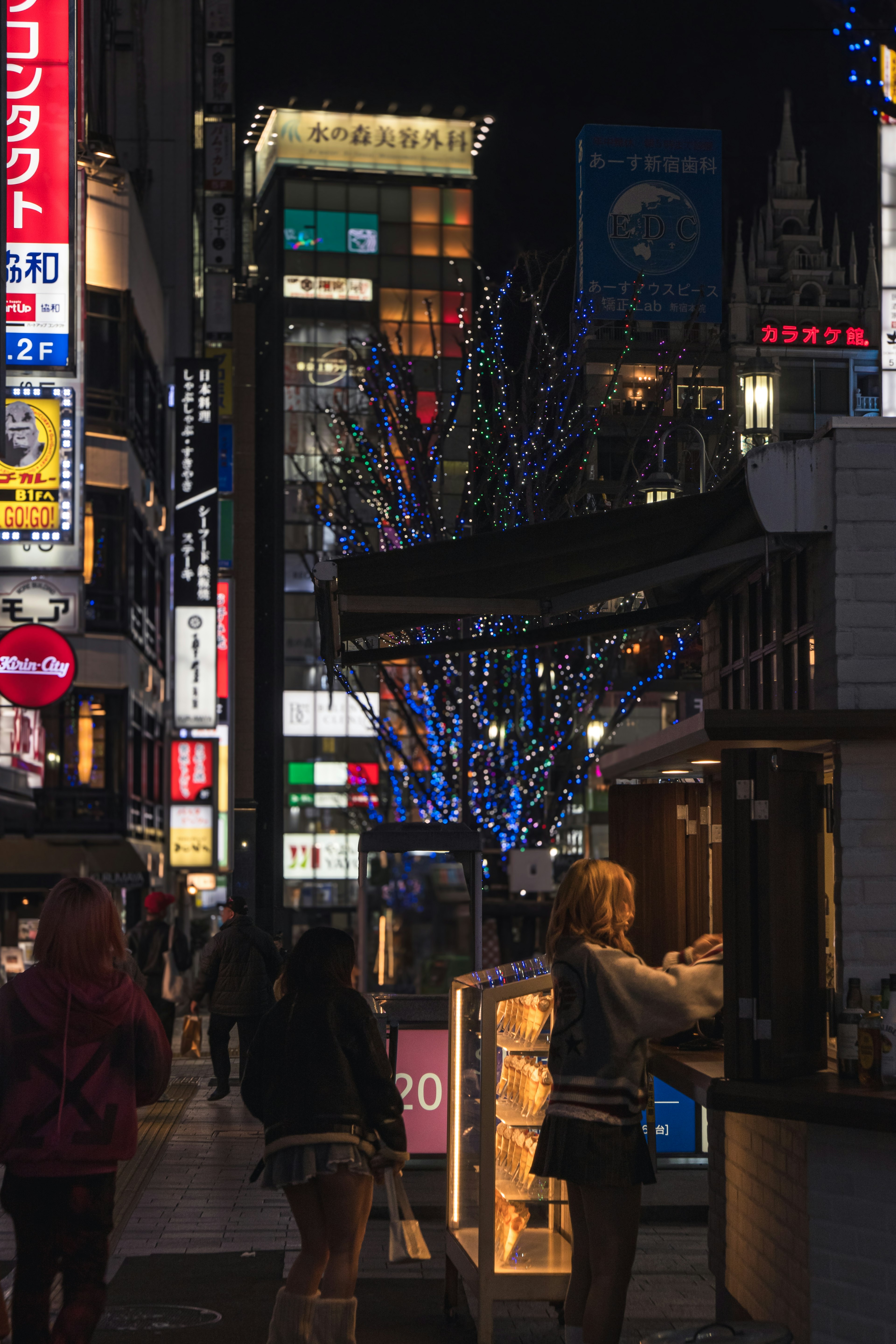 Escena nocturna vibrante de la ciudad con decoraciones iluminadas y personas