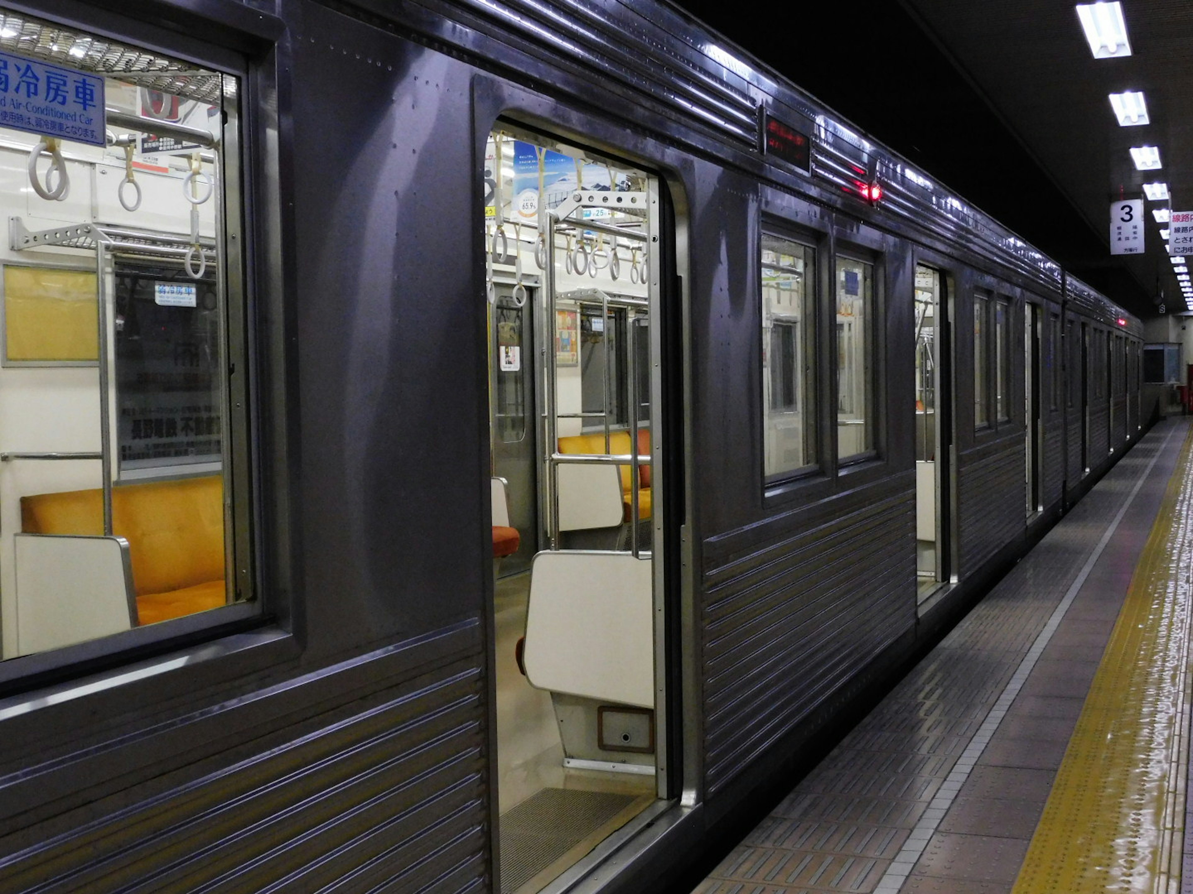 地下鉄の車両が停車している駅のホーム。ドアが開いている車両の内部が見える