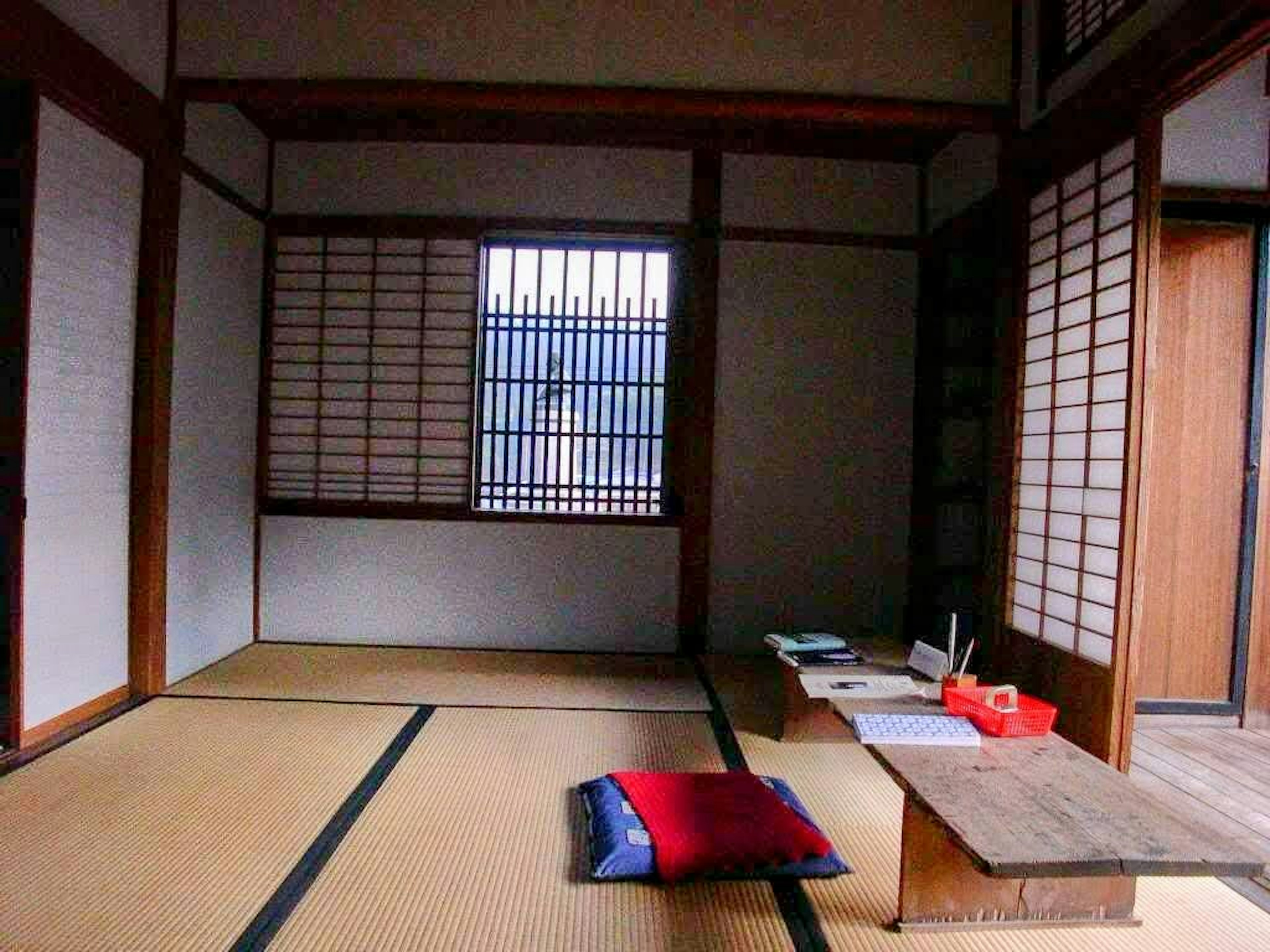 Intérieur d'une chambre japonaise traditionnelle avec un sol en tatami et une lumière naturelle entrant par la fenêtre