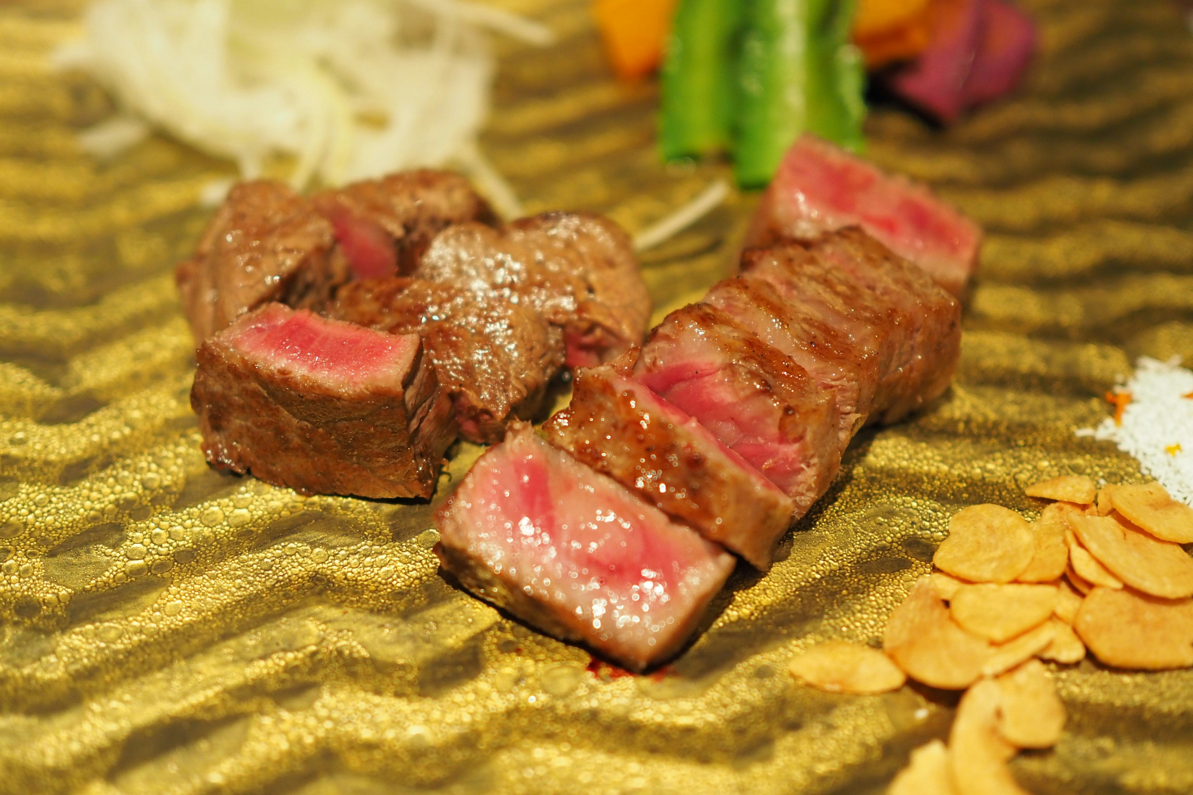 Succulent slices of pink steak arranged on a golden plate