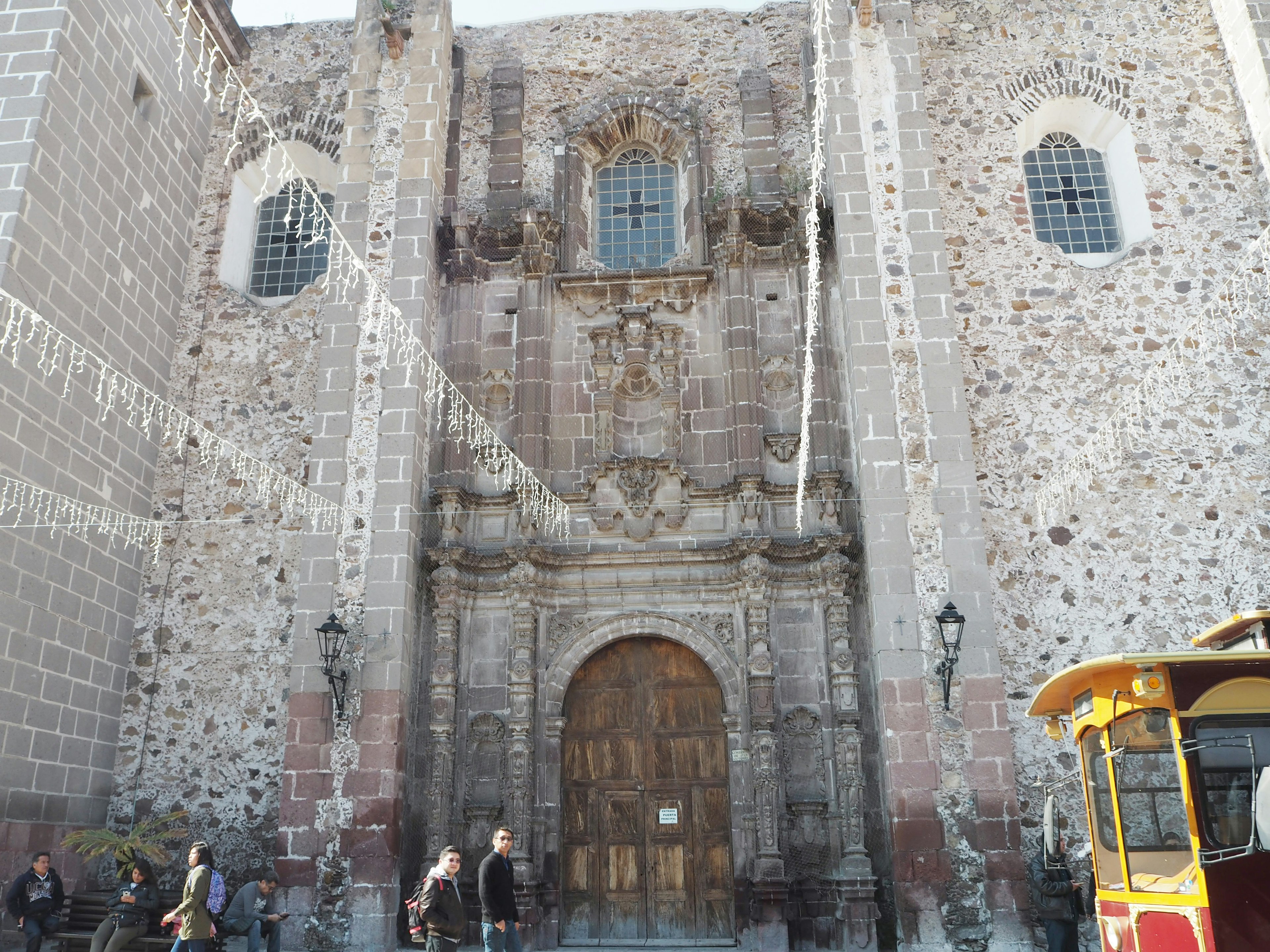 Facade of an ancient church with stone walls and decorative small windows