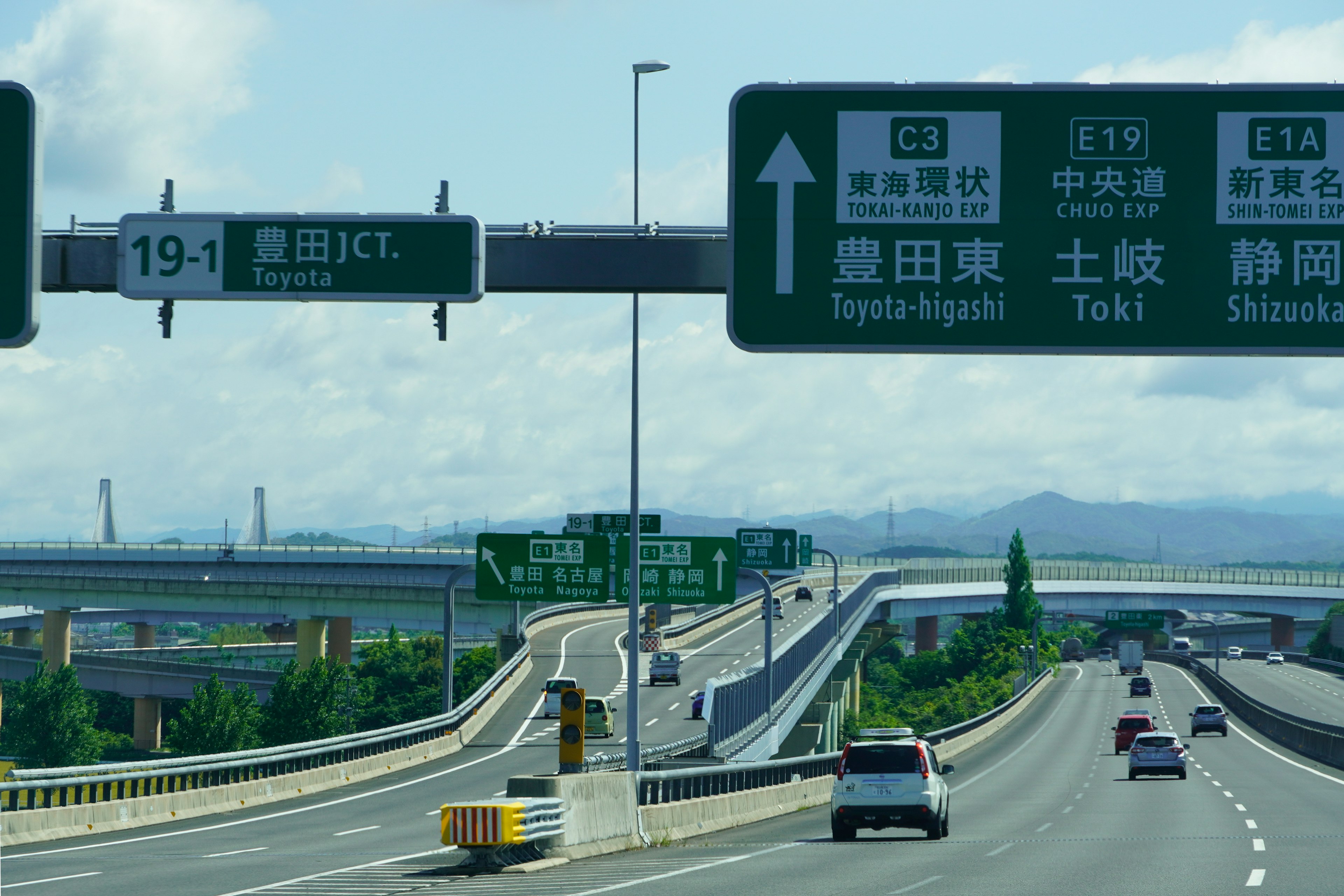 高速道路の標識と車両が見える風景