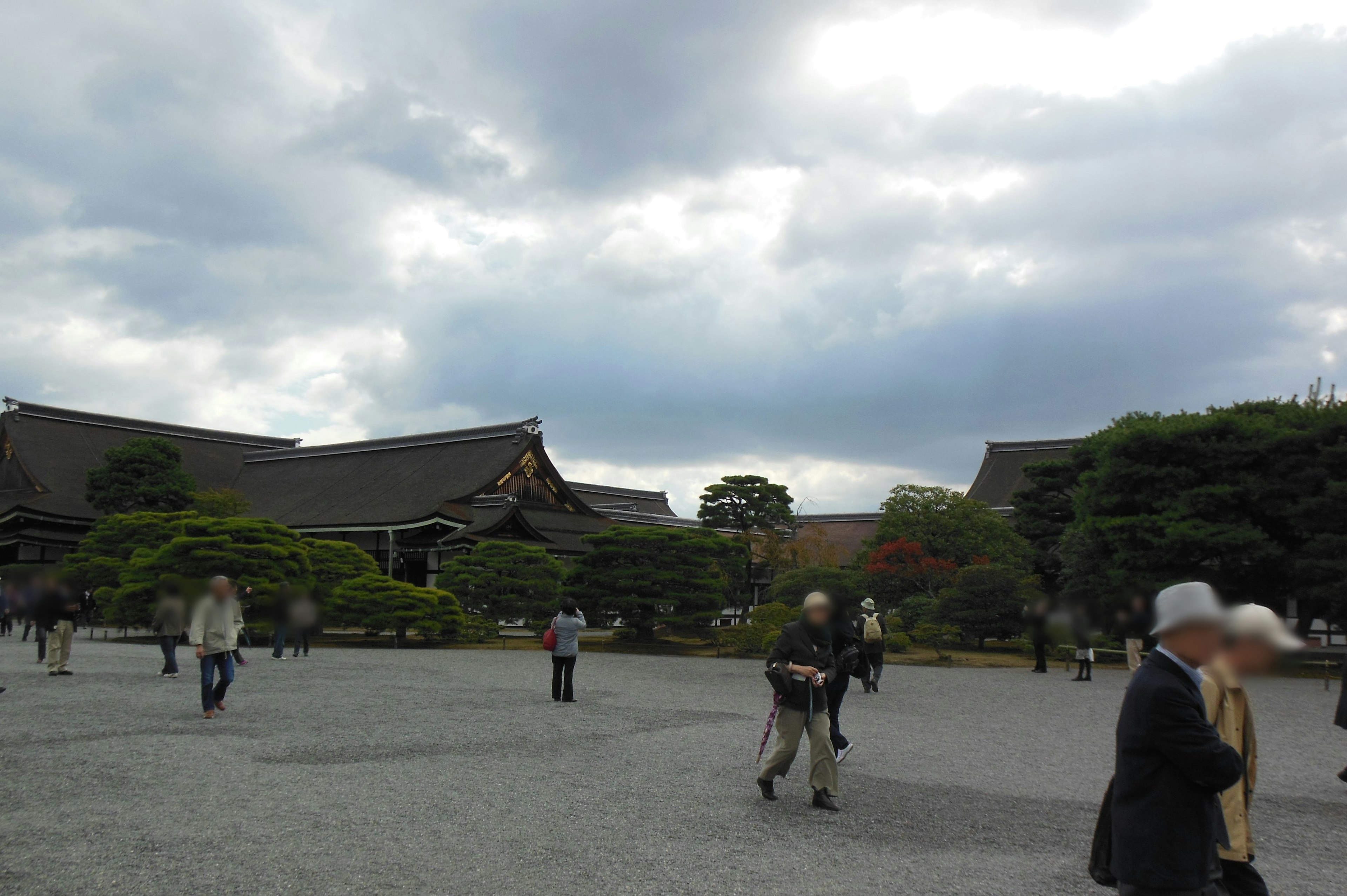 人々が歩いている庭園の風景と曇り空