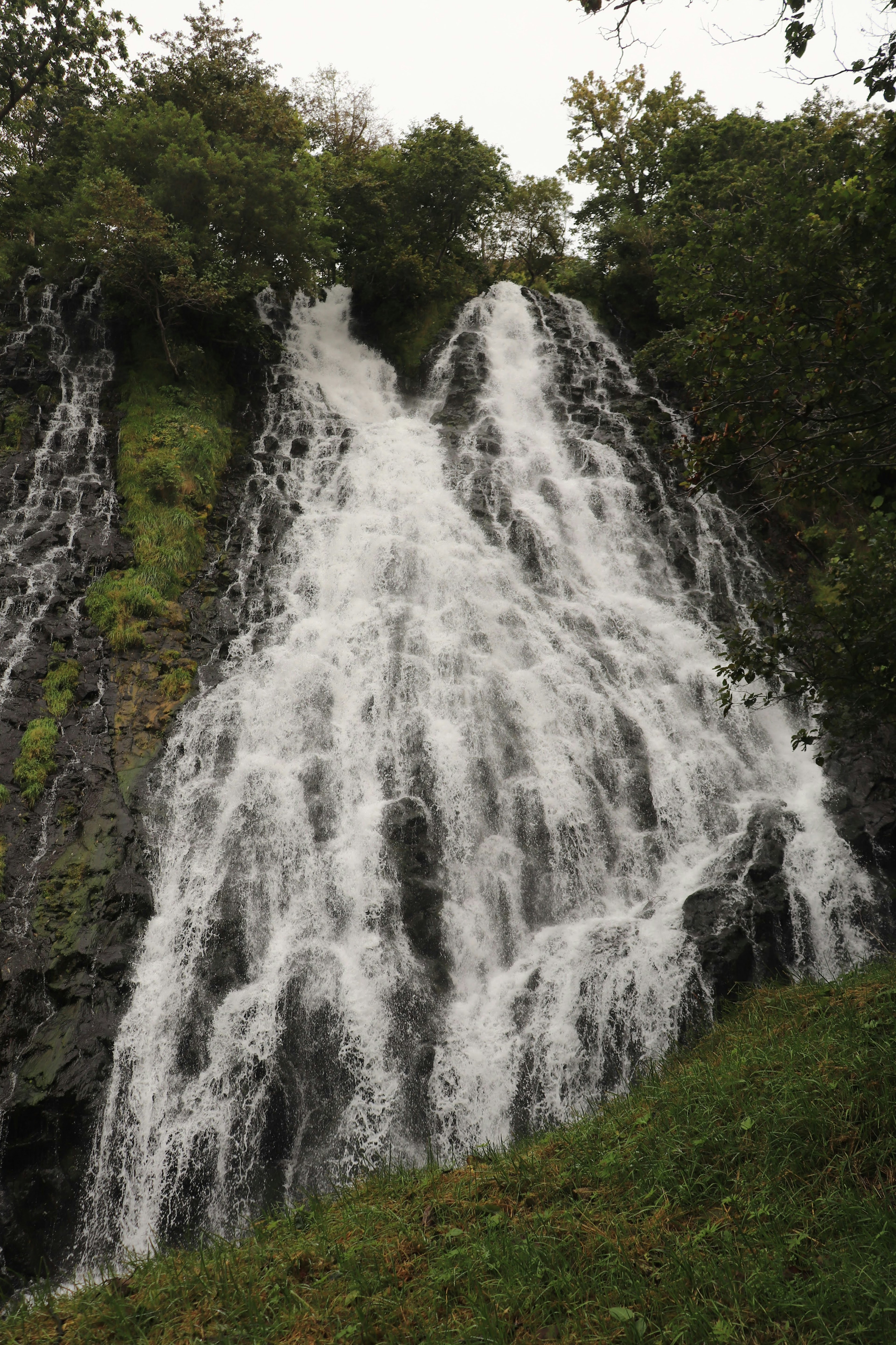 Air terjun dikelilingi oleh vegetasi subur