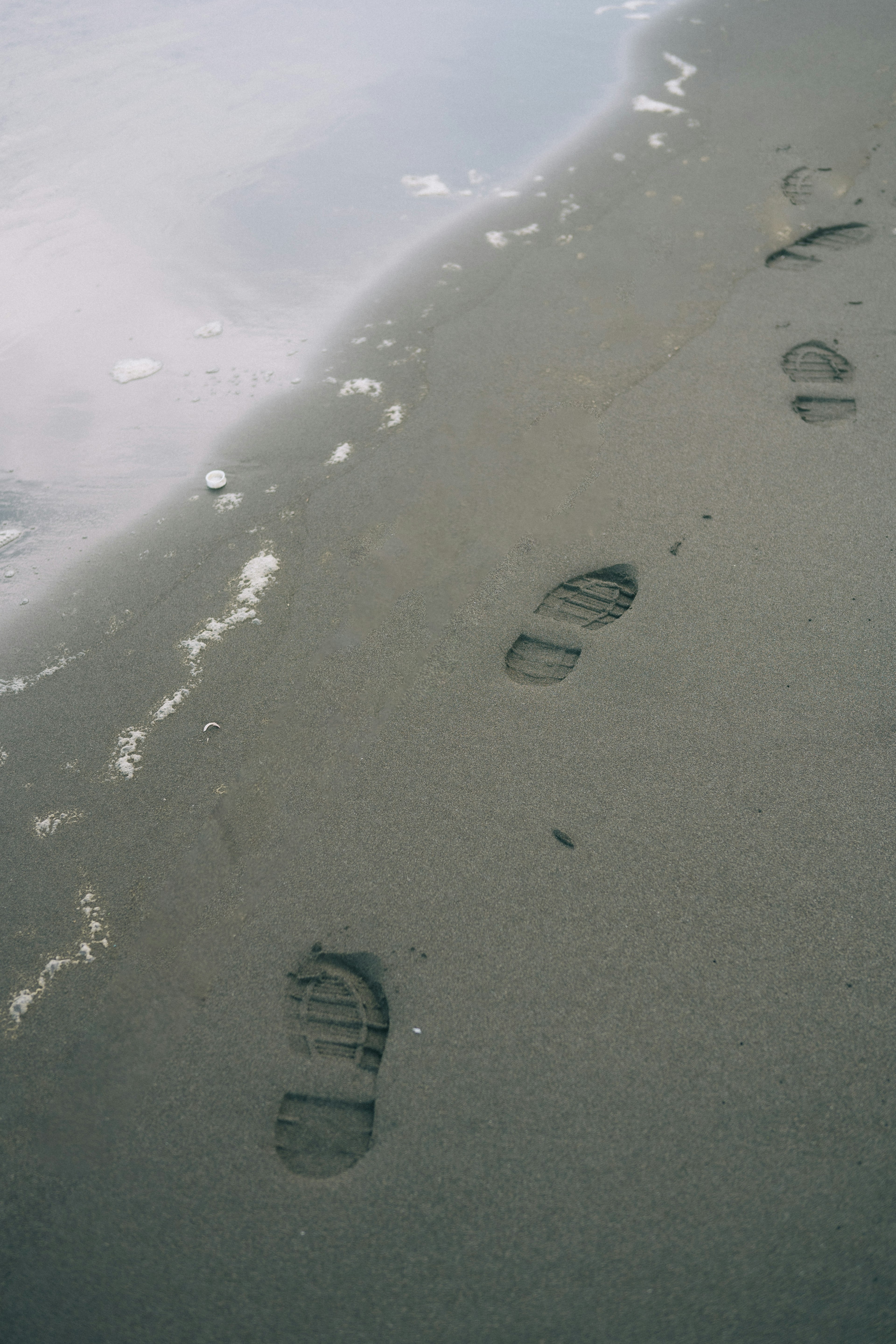 Footprints on the sand near the tide