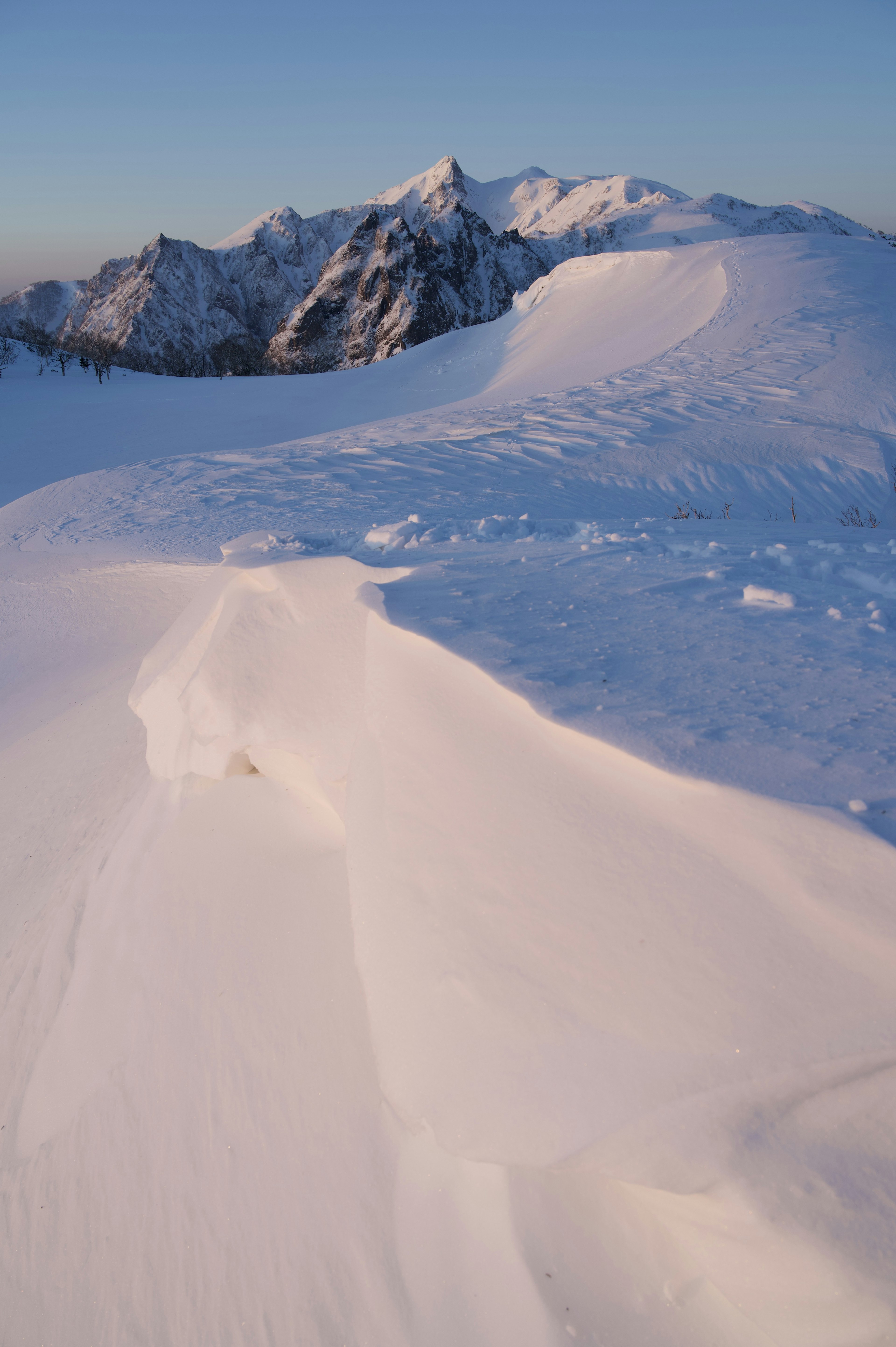 Snow-covered mountain range with smooth snow slopes