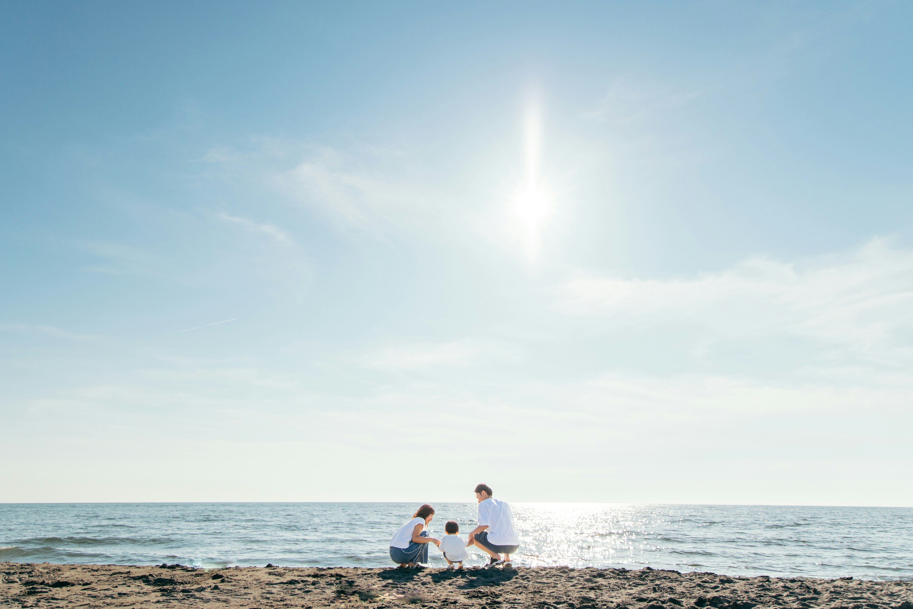 Famiglia che trascorre del tempo insieme sulla spiaggia sotto un cielo azzurro