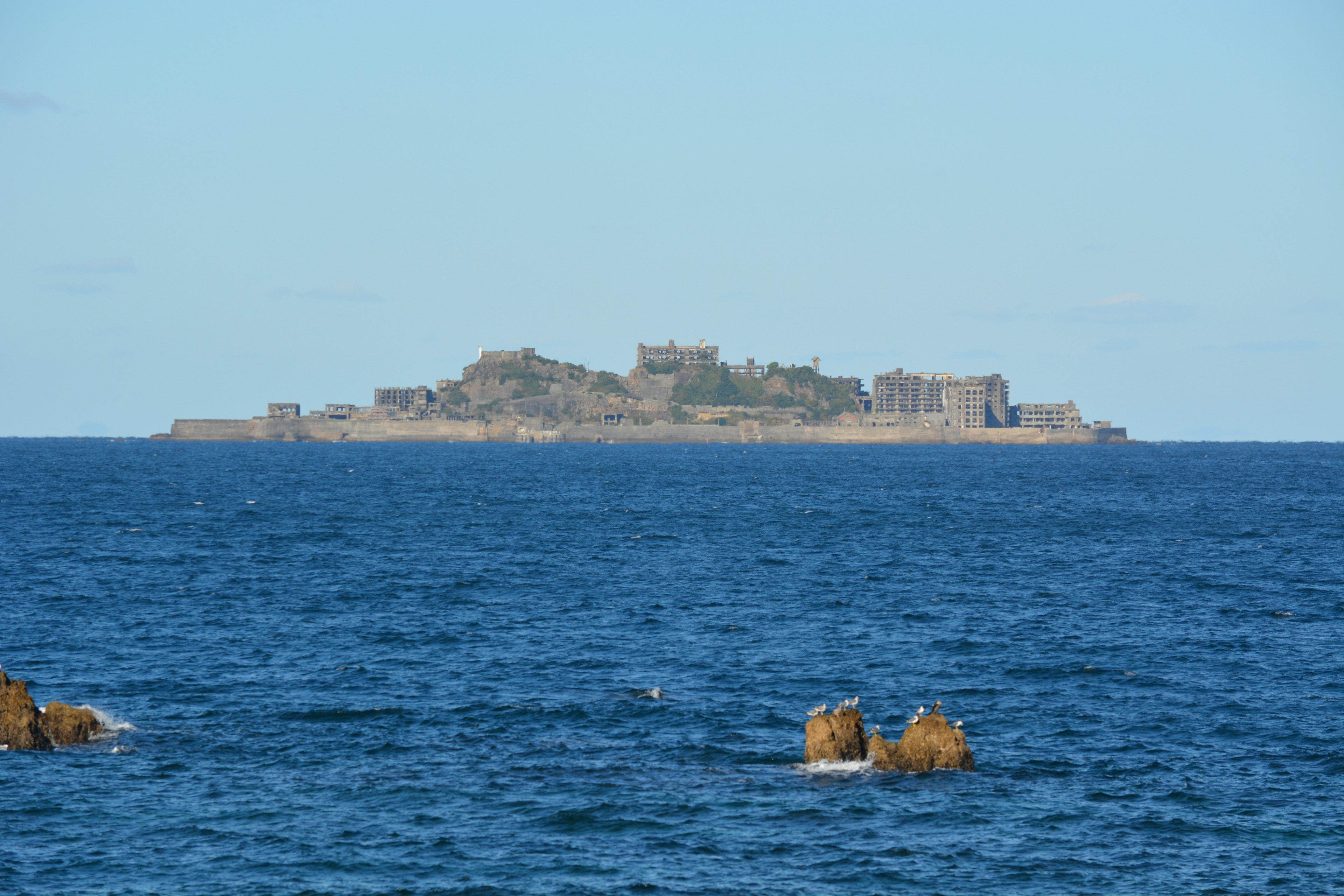 Isla con fortificaciones a lo lejos rodeada por un océano azul