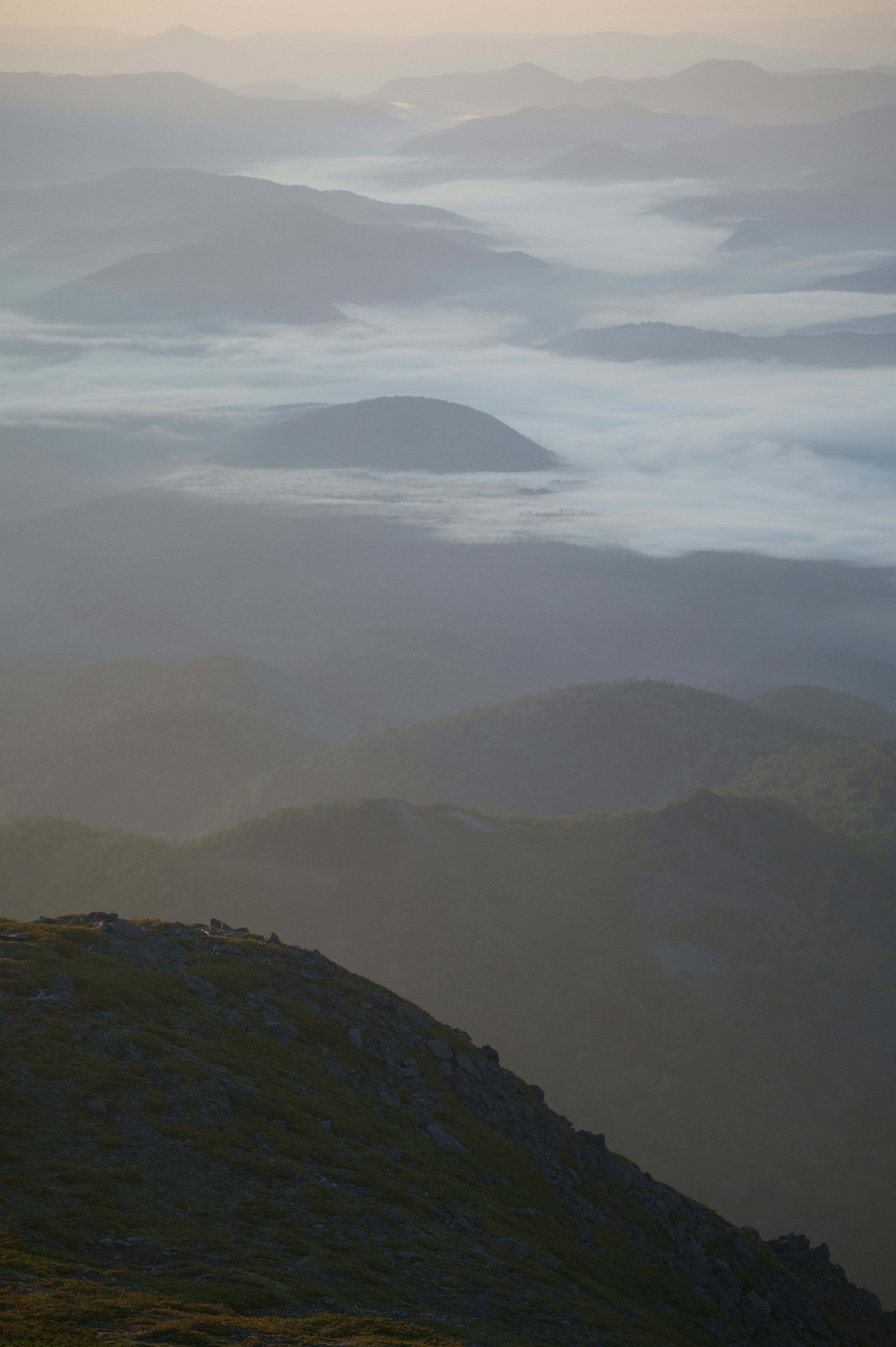 Paisaje matutino de montañas cubiertas de niebla con suaves capas