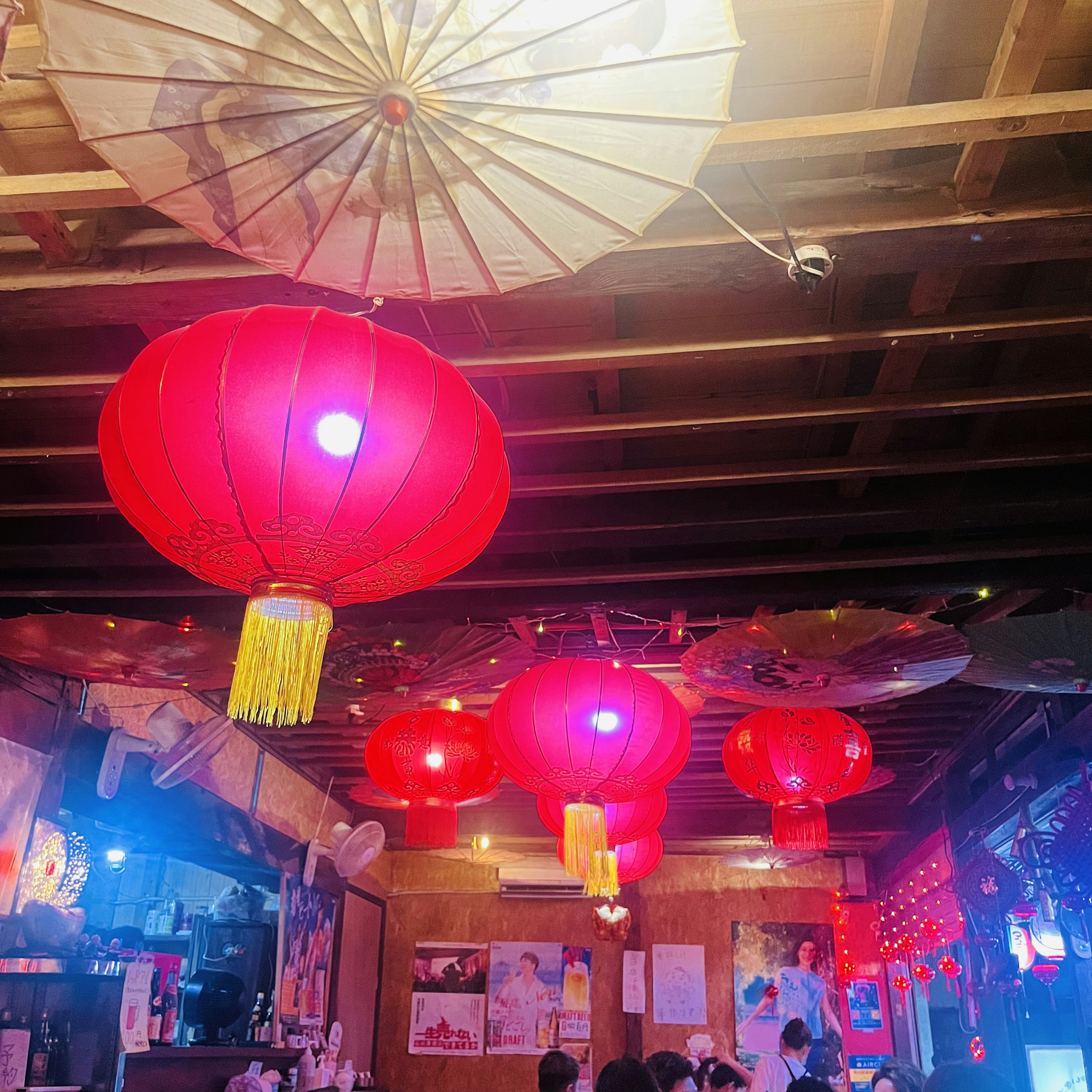 Interior of an izakaya decorated with red lanterns and Japanese umbrellas