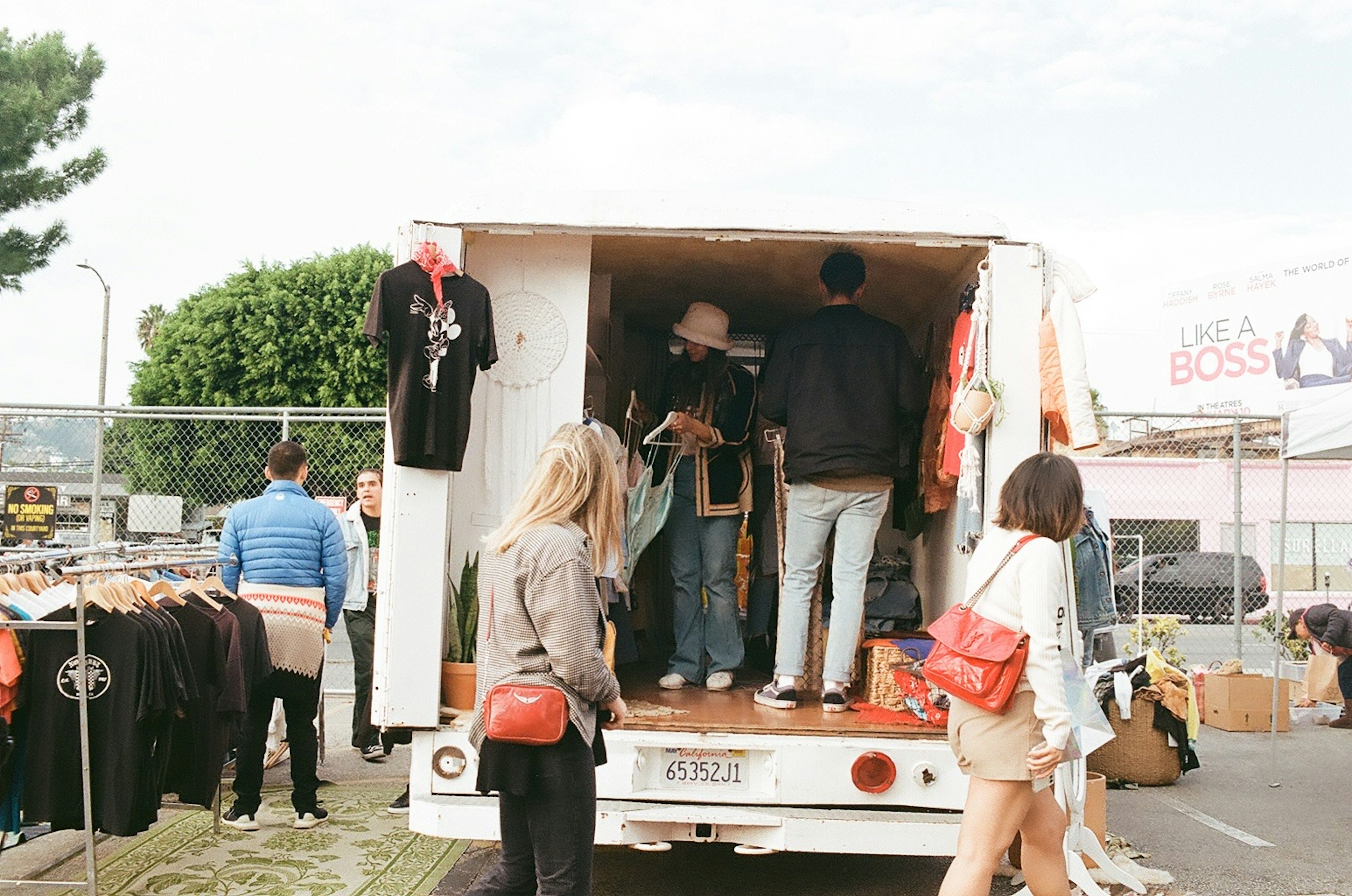 People exploring clothes in the back of a truck