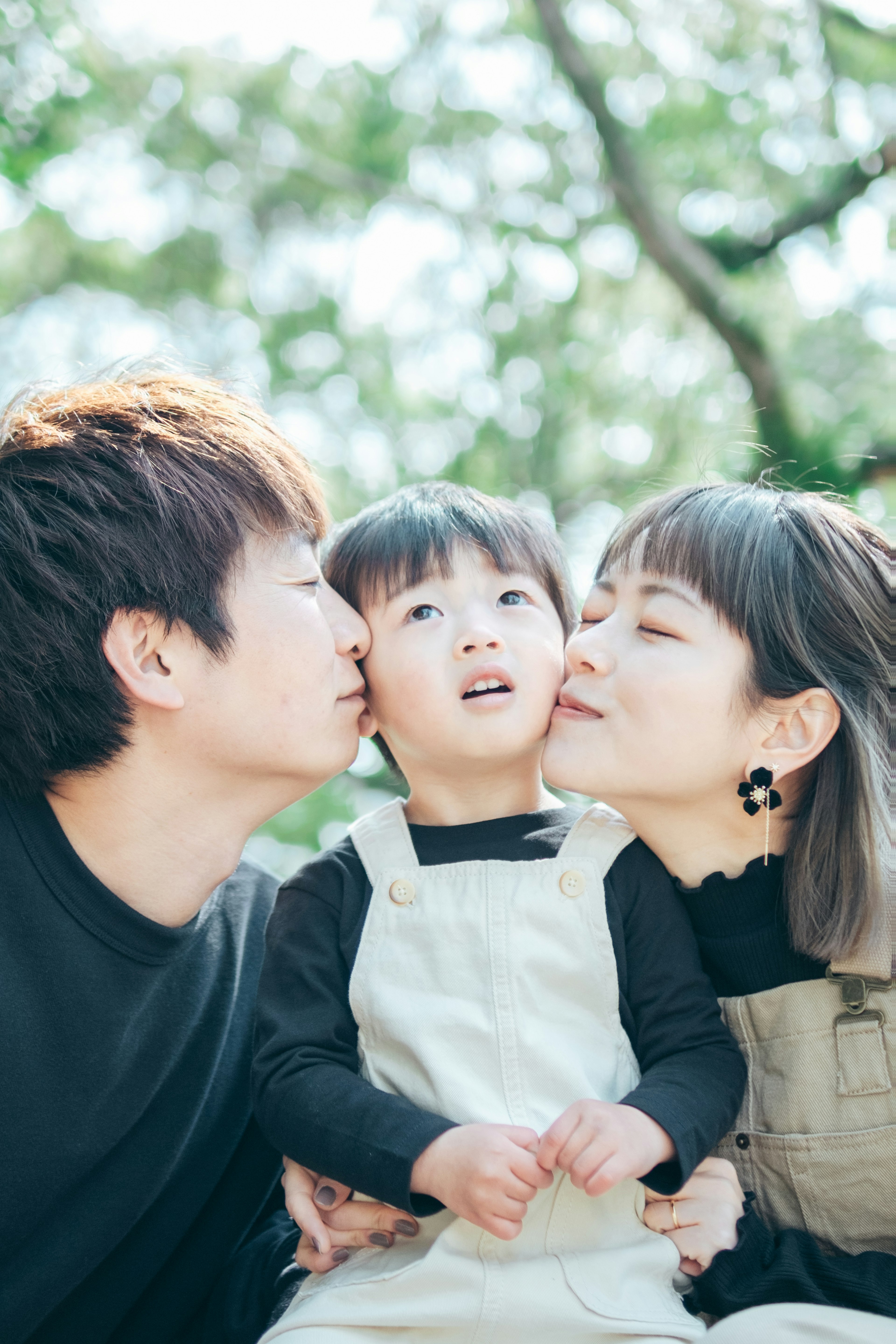 Portrait de famille avec des parents et un enfant souriant ensemble dans un cadre naturel