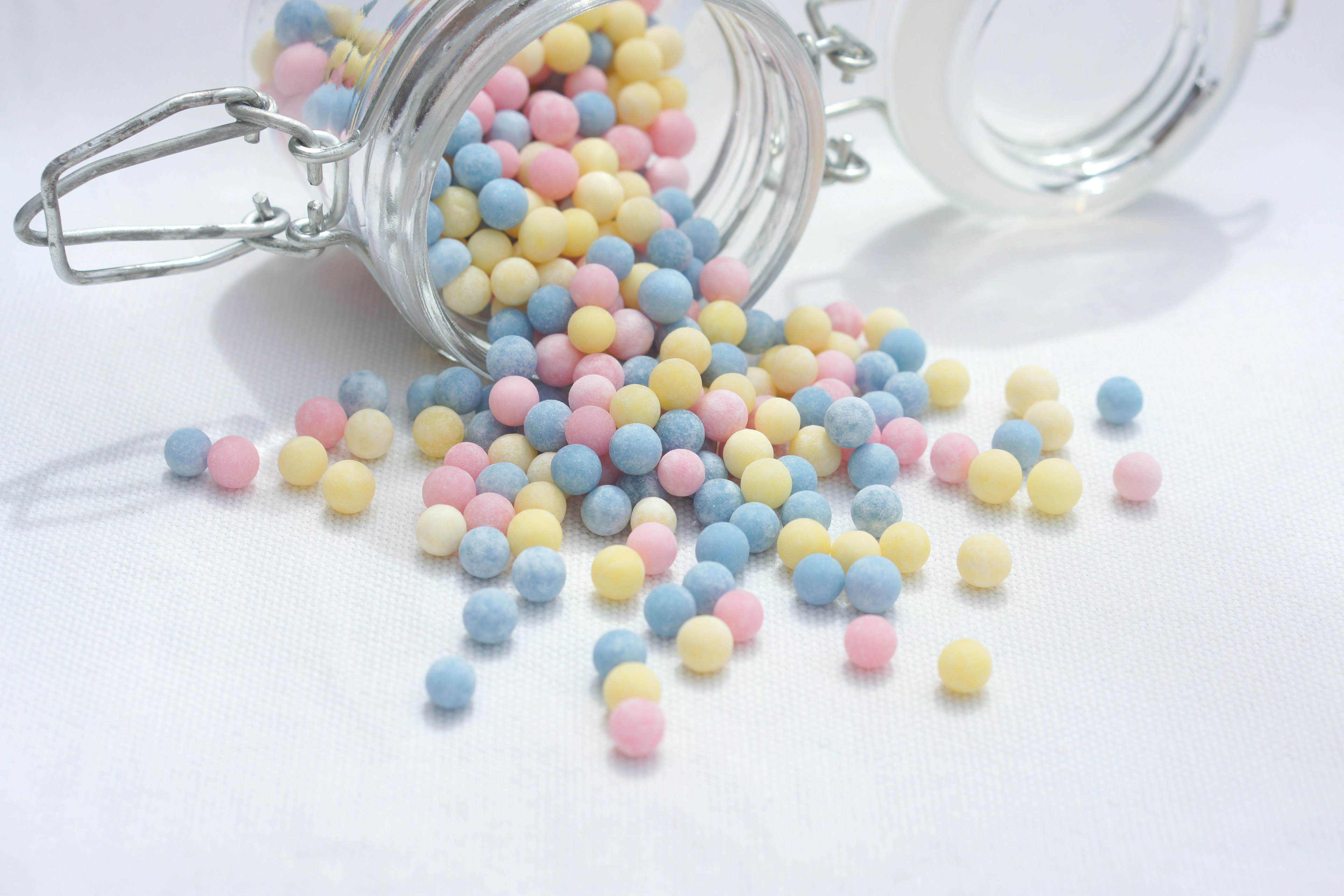 Colorful small balls spilling out of a clear jar